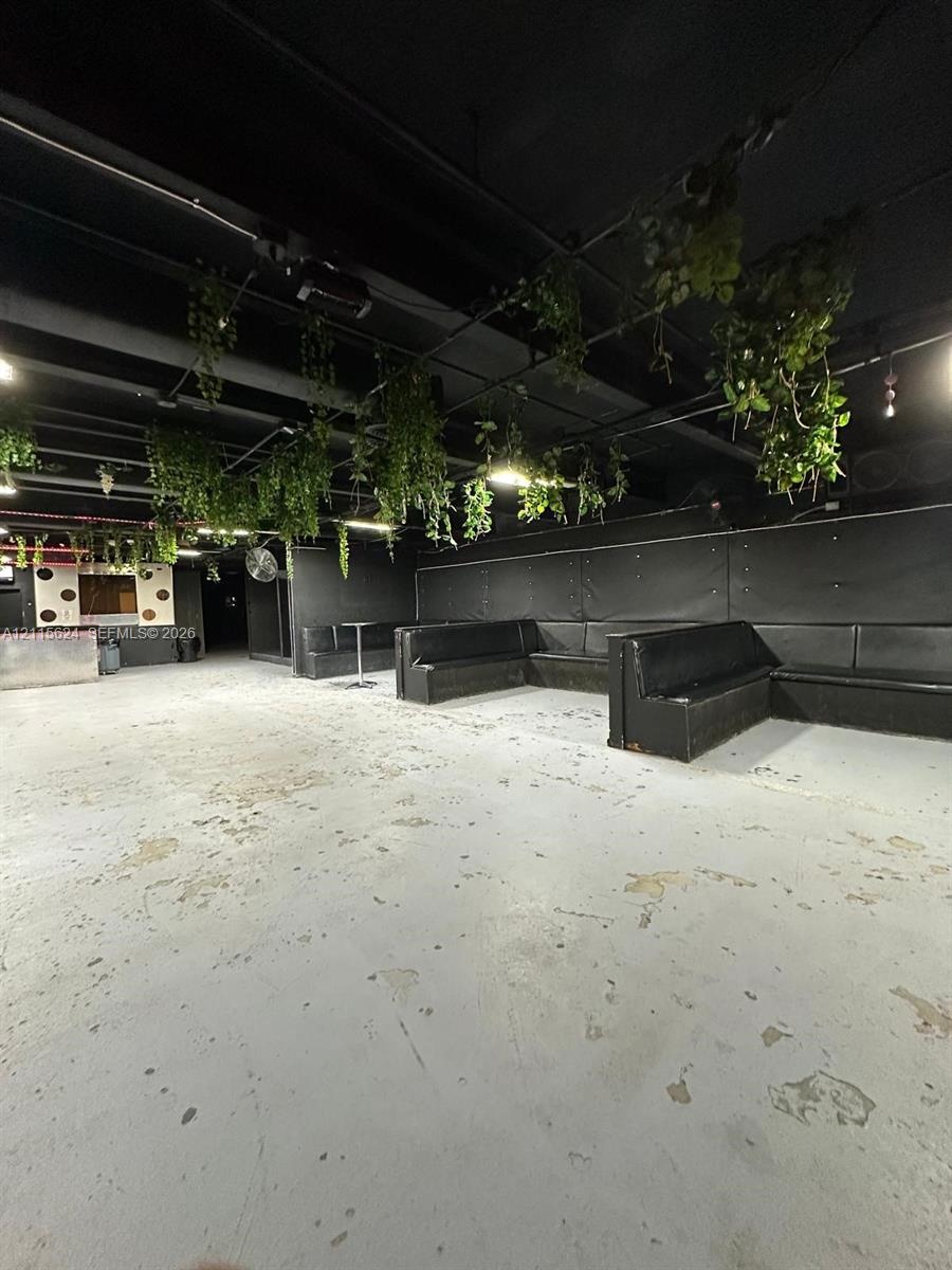 Expansive industrial-style interior featuring high ceilings with exposed ductwork, concrete flooring, and built-in perimeter bench seating
