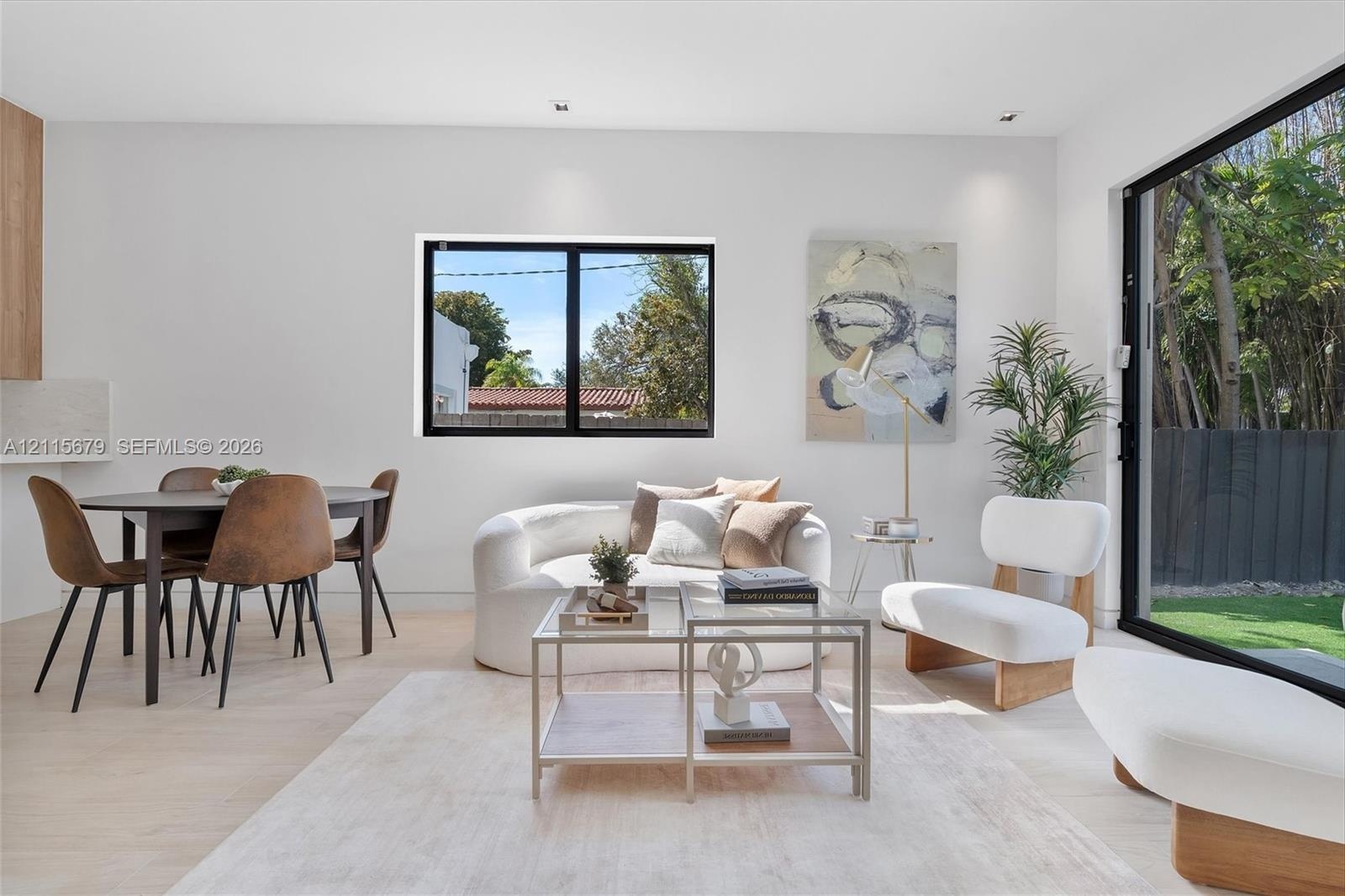 Open-concept living space featuring wood-finish flooring, recessed lighting, and large sliding glass doors providing outdoor access