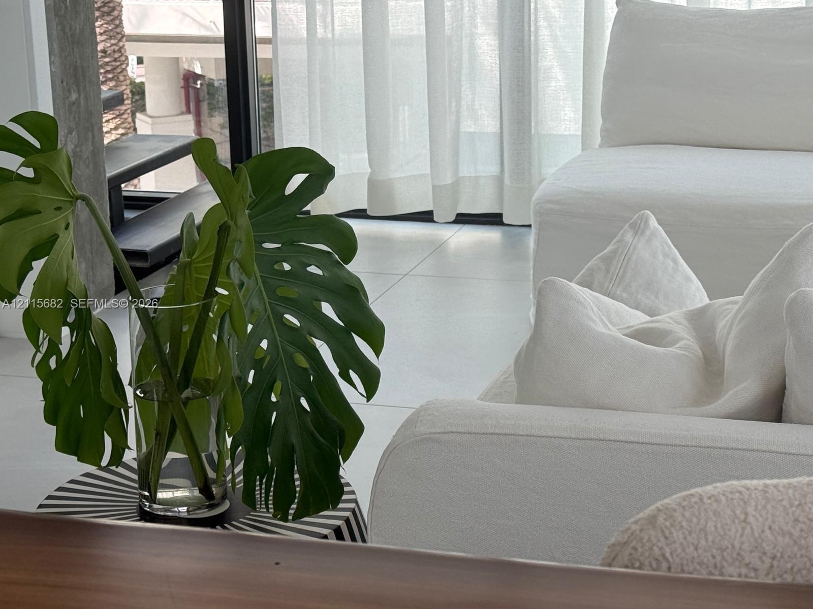 Large-format floor tile, floor-to-ceiling glass sliding doors, and black metal door frames