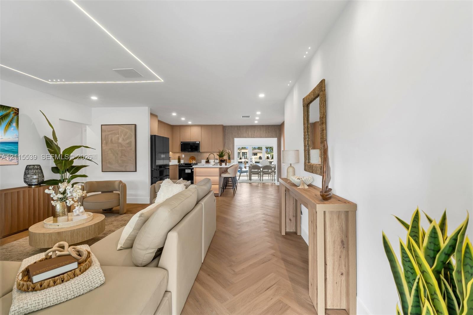 Herringbone wood-finish flooring, recessed ceiling lighting, linear architectural cove lighting, kitchen island with built-in cabinetry, and integrate