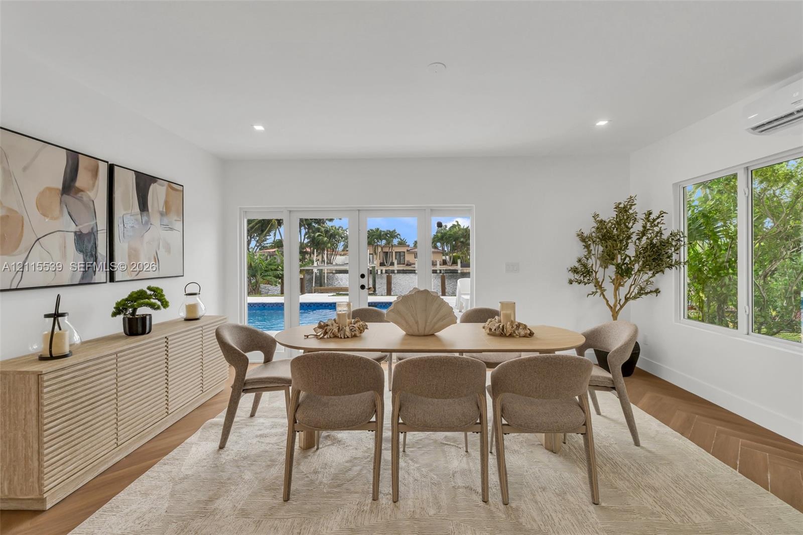 Herringbone-patterned wood-finish flooring, built-in slatted cabinetry, recessed ceiling lighting, and expansive glass paneled doors providing visibil