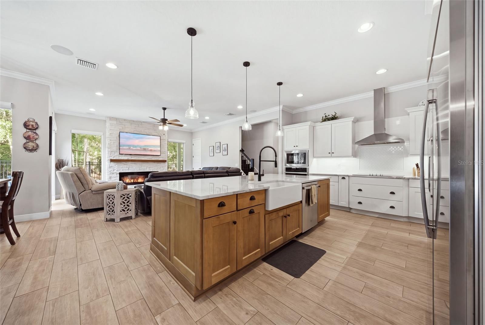 Chef's kitchen featuring plentiful storage, counter tops open to the family room and view of pool and conservation