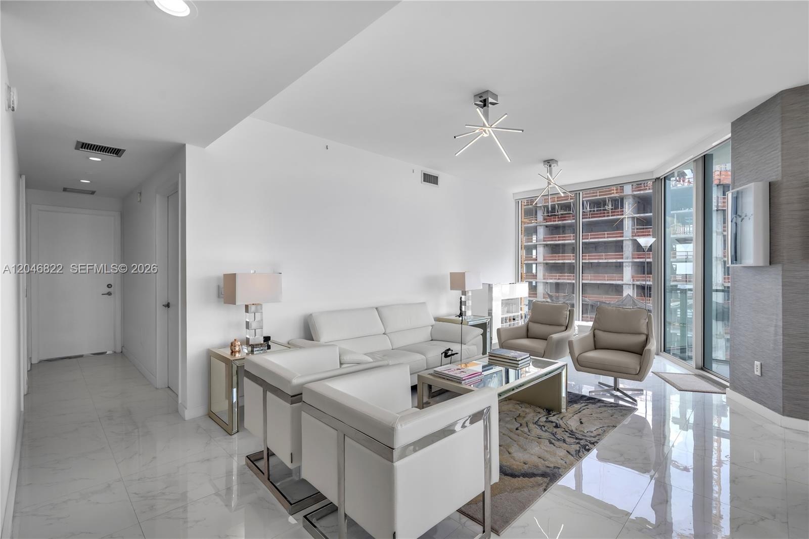 Dining area beneath designer pendants with panoramic city views
