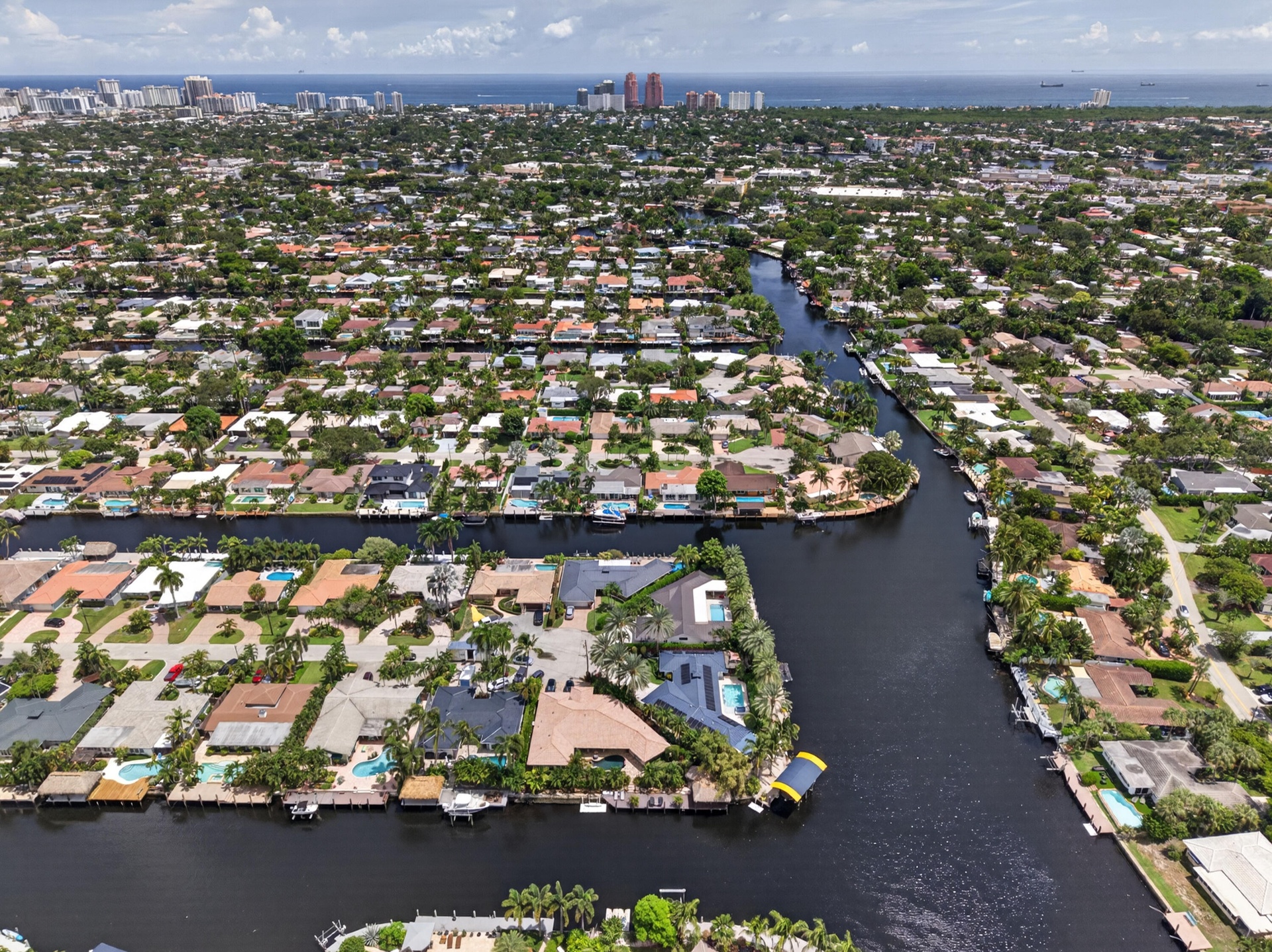 Aerial view Beautiful point lot home with wide waterfront for your boating enjoyment with Fort Lauderdale Beach in the background