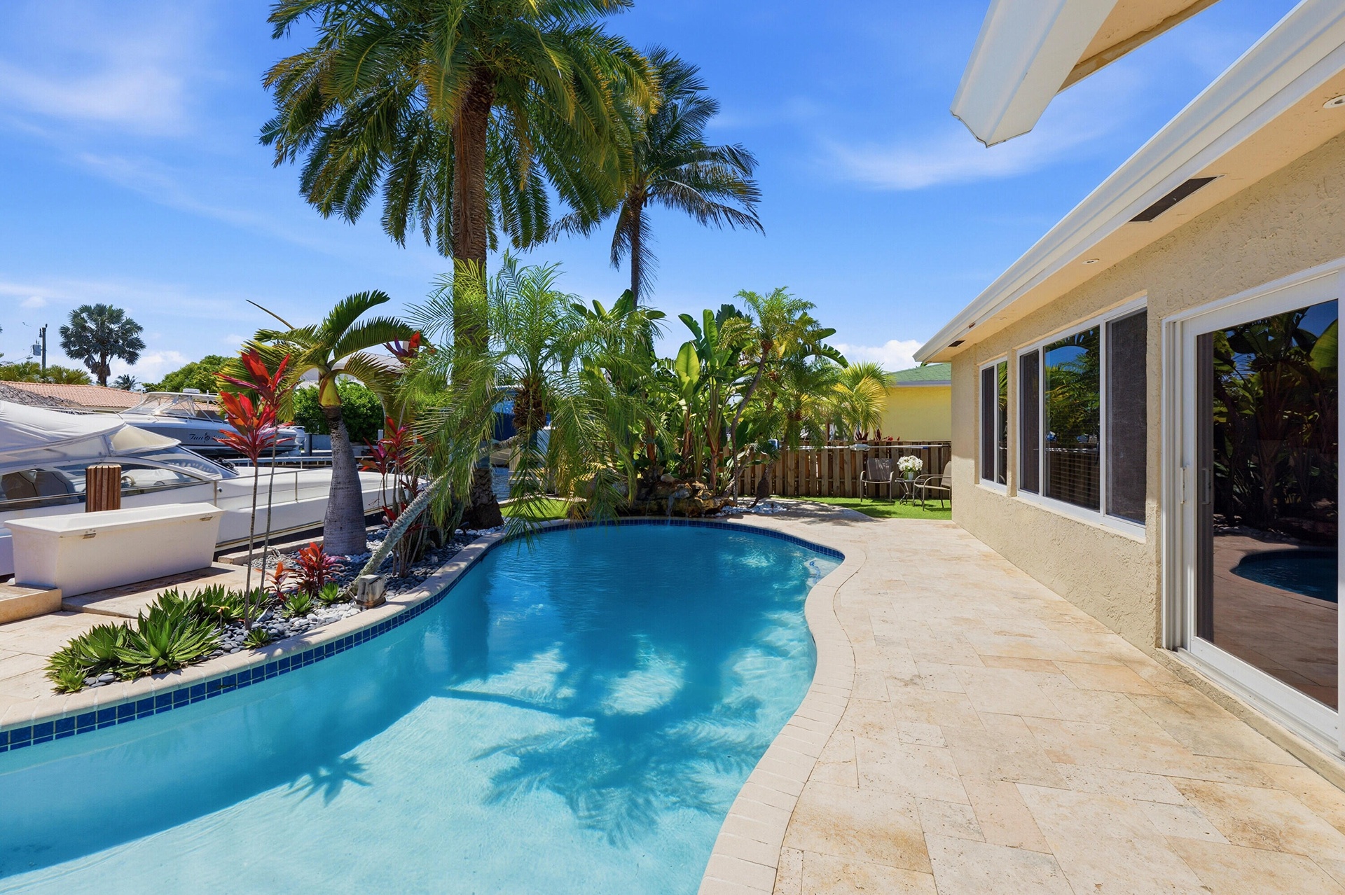 Beautiful Landscape Surrounds Your Waterfront Freeform Pool with Rock Waterfall adds to the Serene Waterfront Lifestyle.