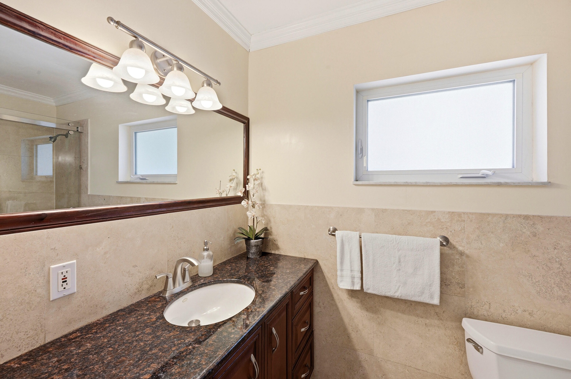 Primary En-Suite Bathoom with Custom Cabinet, Granite Countertop, Bathtub & Shower Combination with Glass Enclosure all behing a Frosted Glass Bathroo
