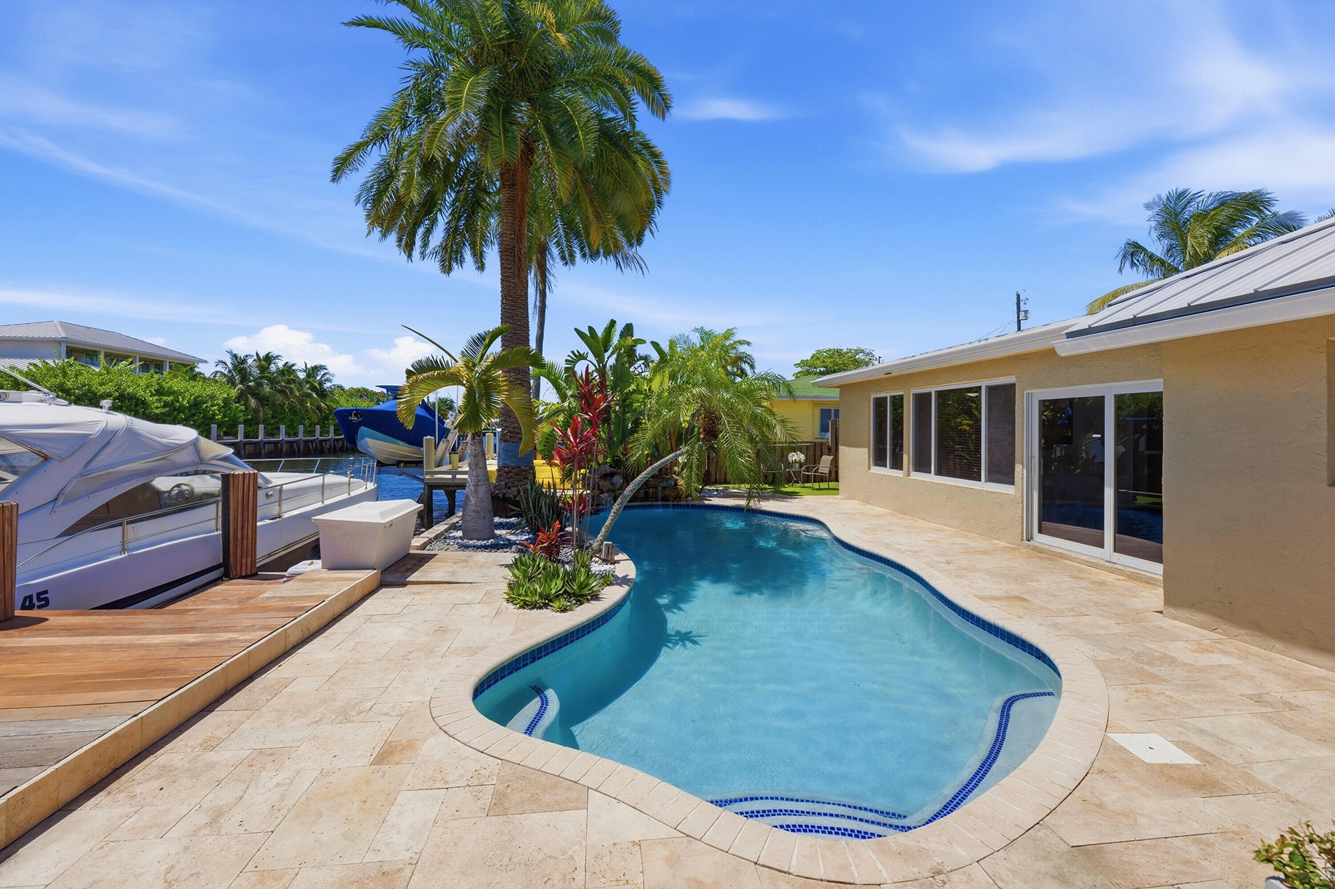 Beautiful Landscape Surrounds Your Waterfront Freeform Pool with Rock Waterfall adds to the Serene Waterfront Lifestyle.