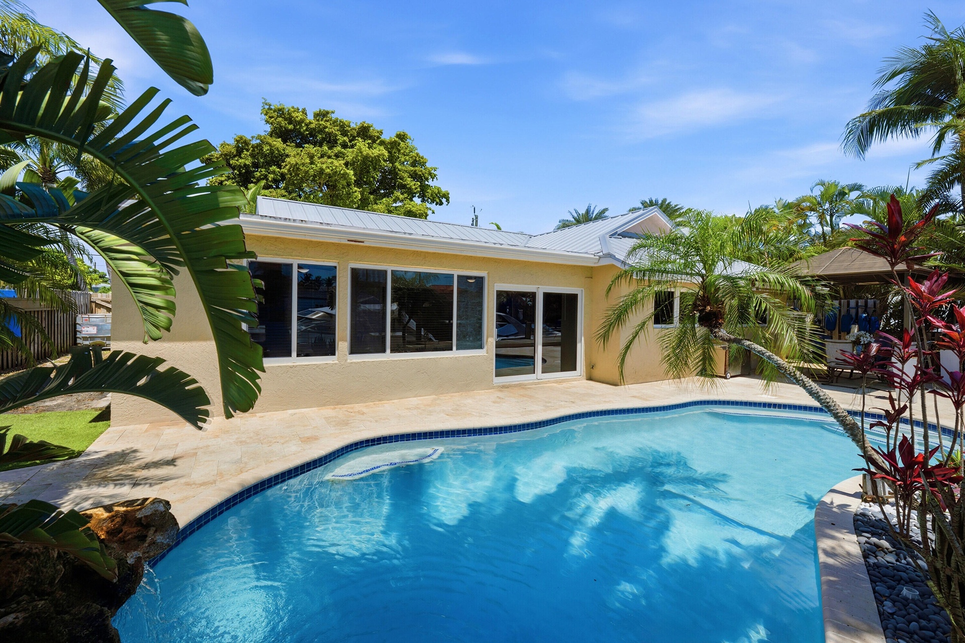 Beautiful Landscape Surrounds Your Waterfront Freeform Pool with Rock Waterfall adds to the Serene Waterfront Lifestyle.