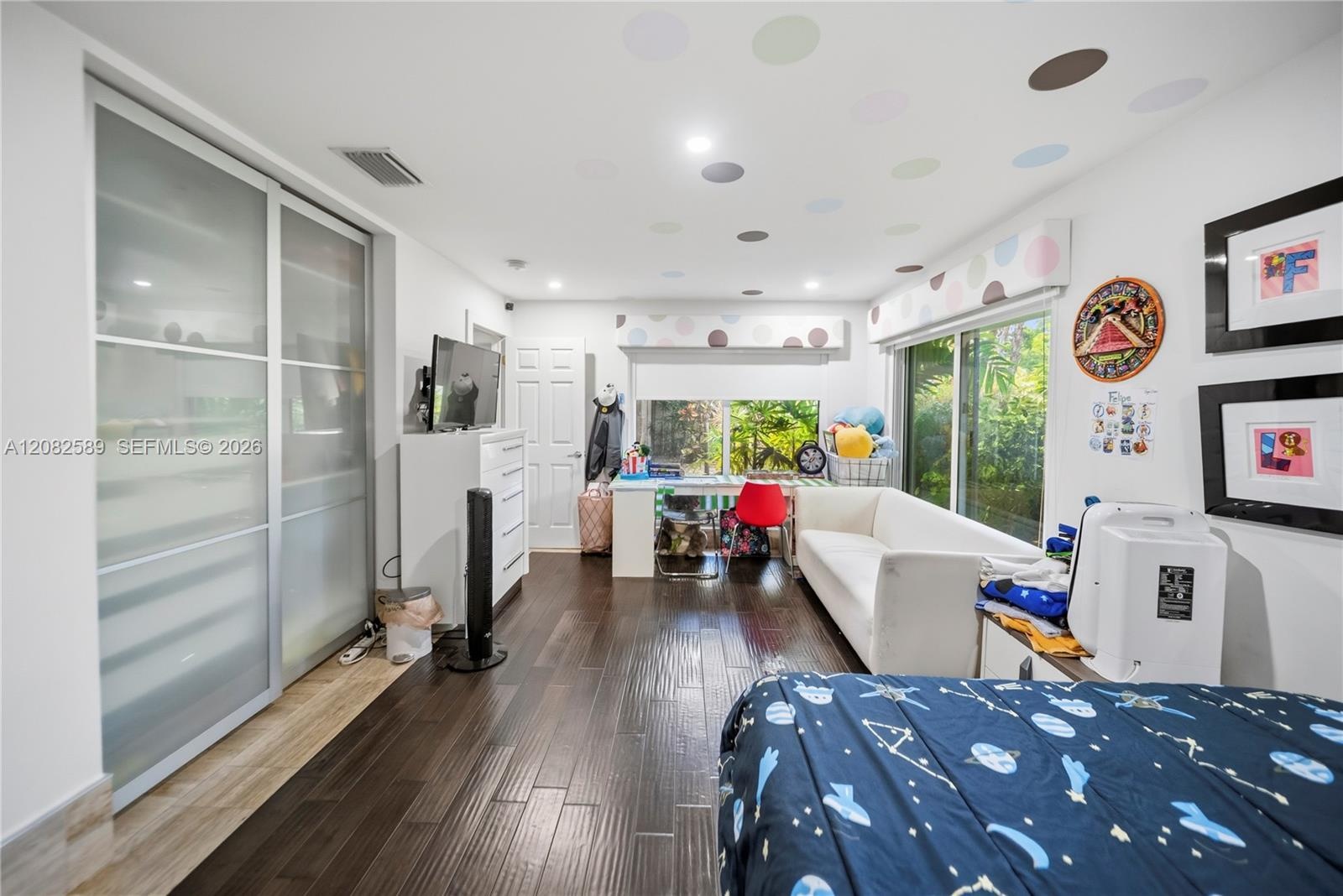 A spacious secondary bedroom 2 designed for comfort, featuring abundant natural light, a generous closet, and peaceful garden views.