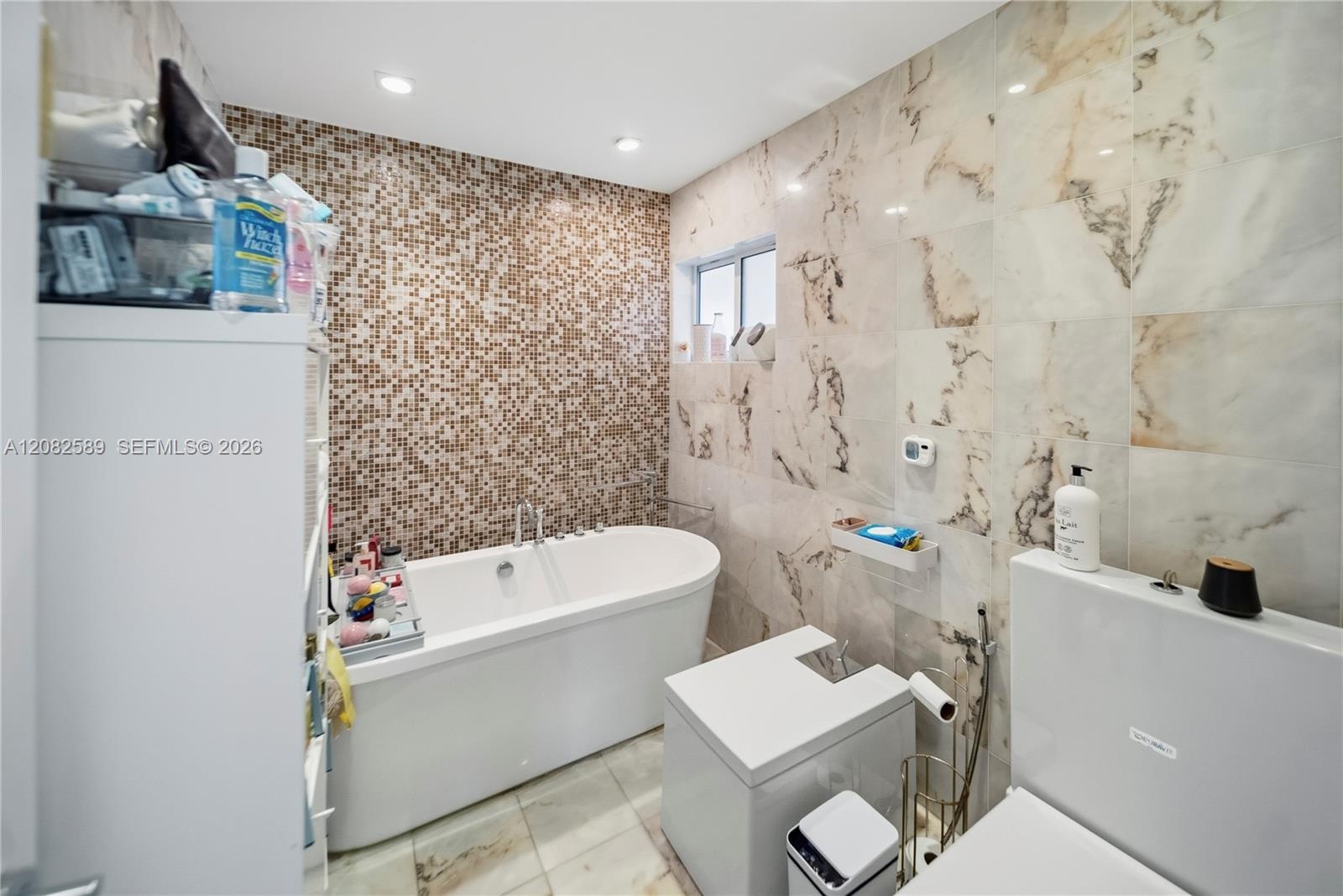 A beautifully finished primary bathroom featuring a relaxing soaking tub and refined marble-inspired details.