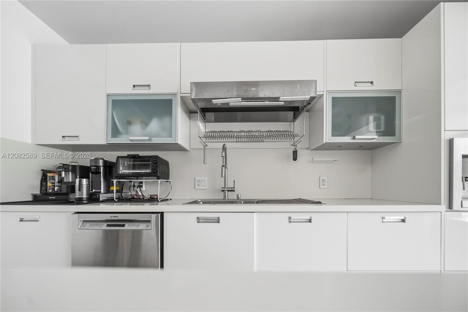 Sleek kitchen workspace featuring modern cabinetry, stainless-steel dishwasher, and contemporary sink area.