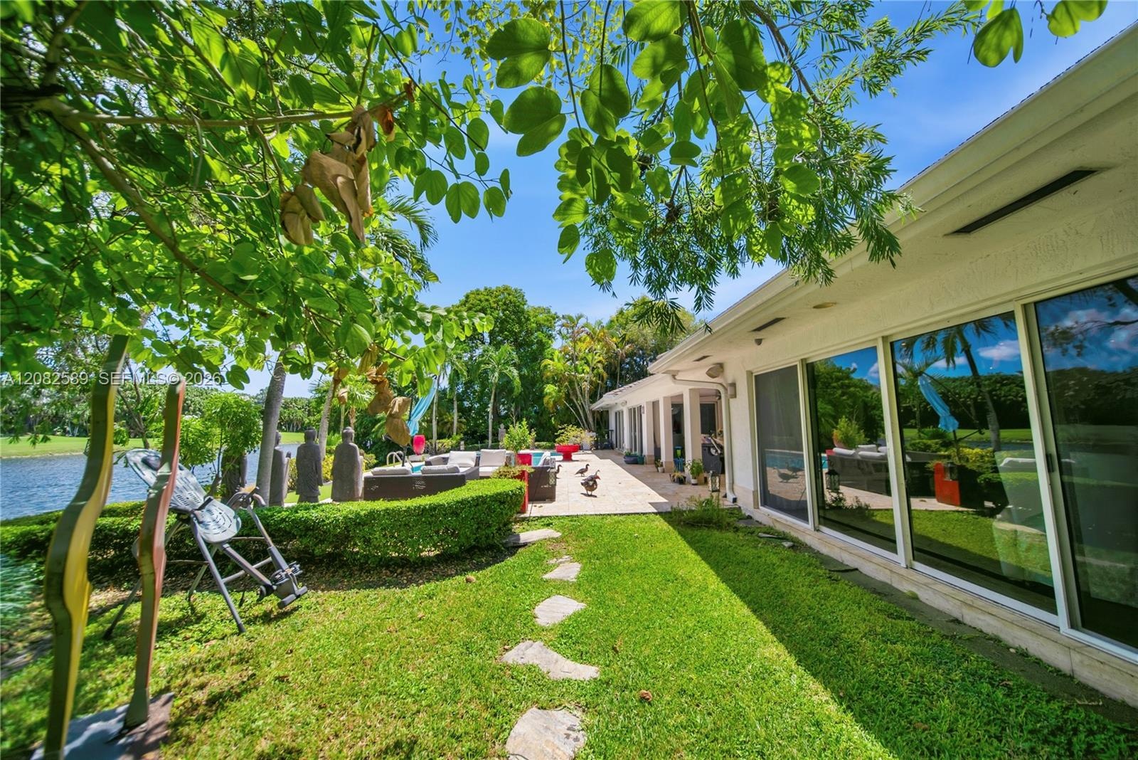 Lush private garden with tropical landscaping, peaceful lake views, and direct access to the poolside terrace.