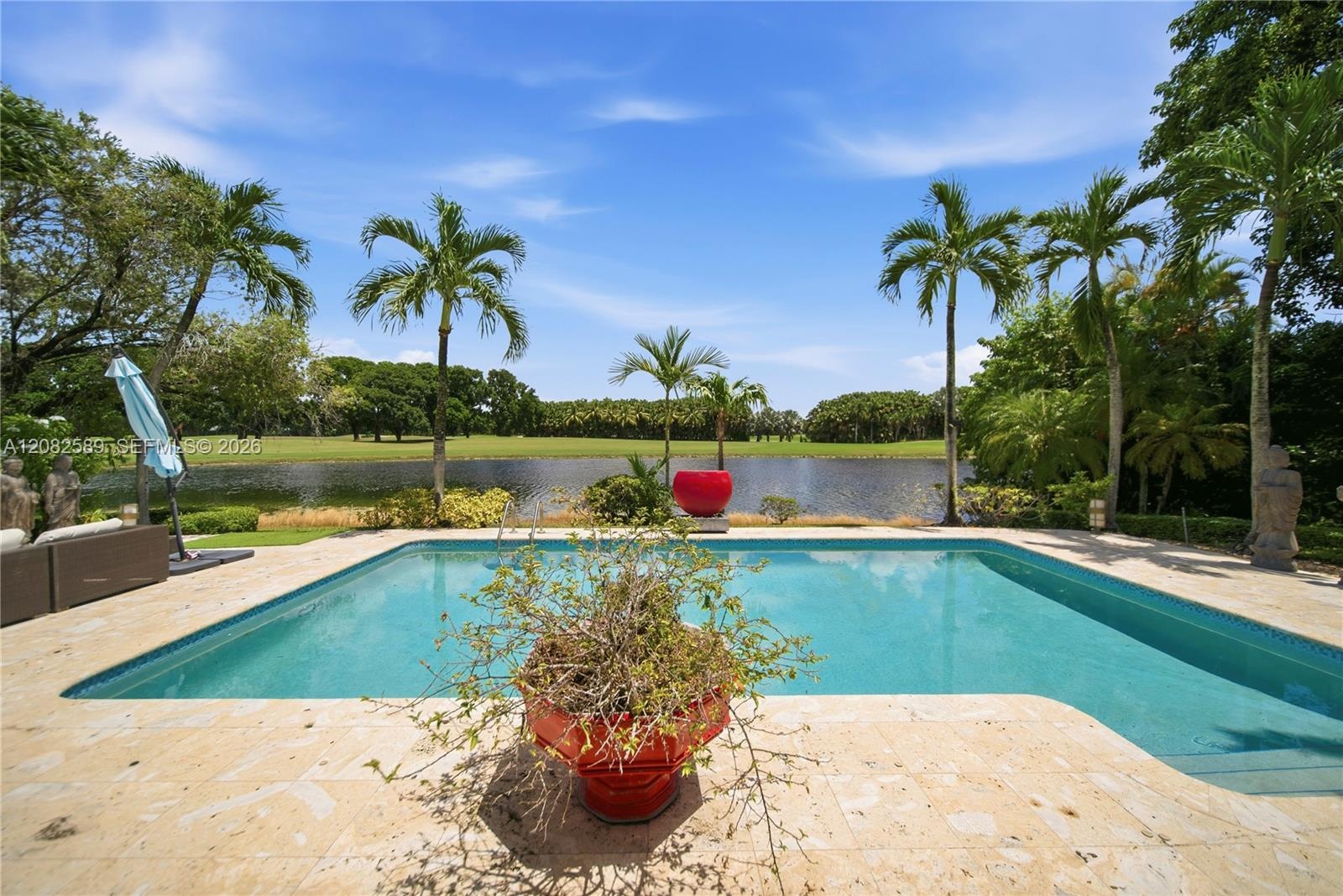 Resort-style pool surrounded by lush tropical landscaping, offering breathtaking lake and golf course views.