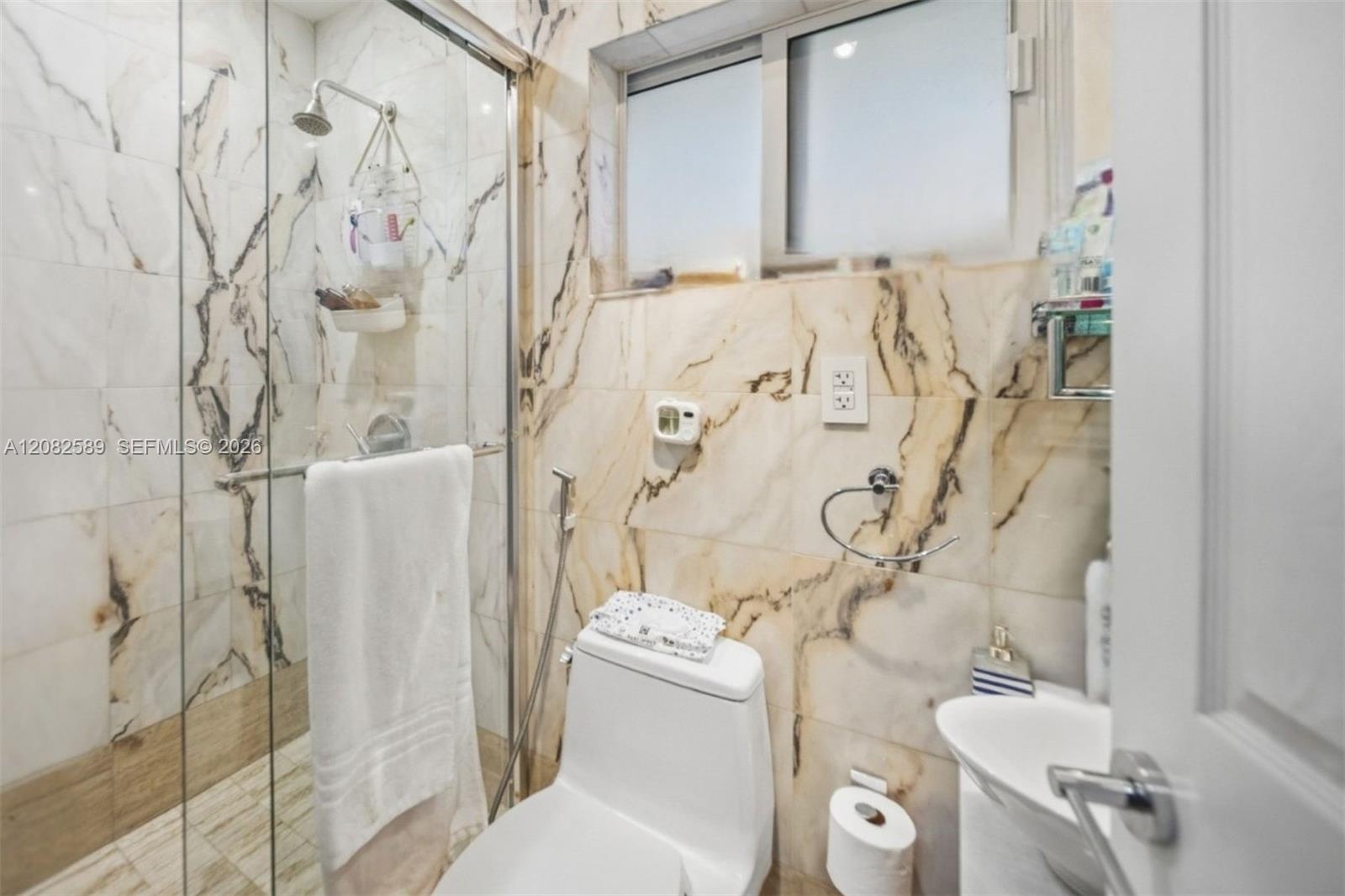 Modern full bathroom featuring marble-style finishes and a glass-enclosed walk-in shower. En-suite of Secondary Bedroom 1