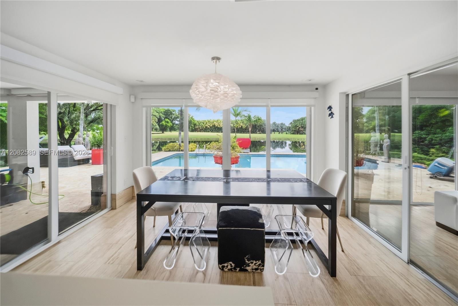Sun-filled breakfast area showcasing panoramic pool and tranquil water views.
