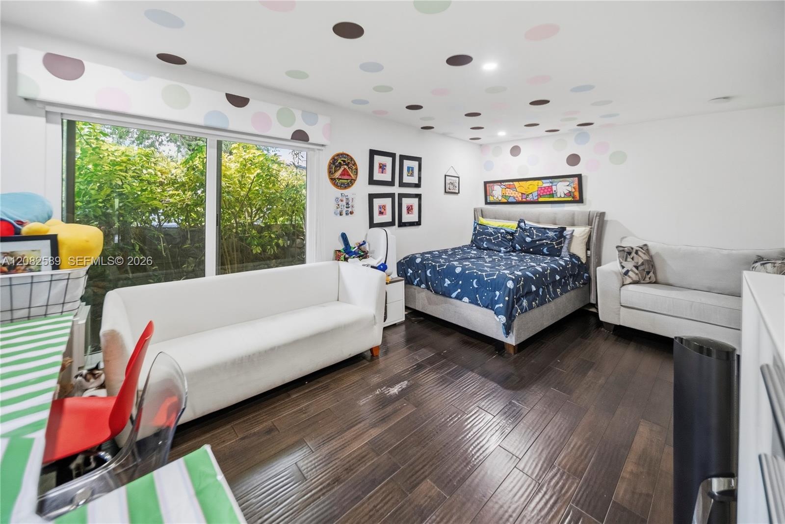 Bright and inviting secondary bedroom 2 with playful details, generous space, and beautiful garden views.