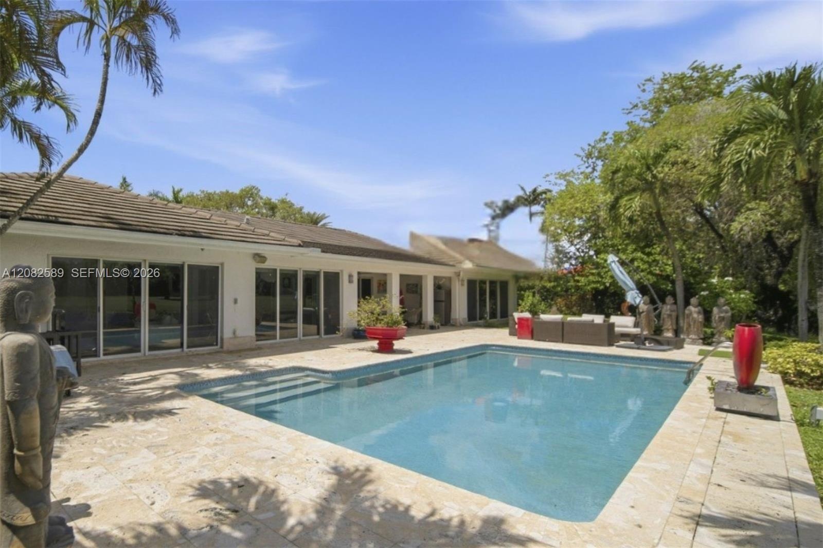 Inviting outdoor retreat featuring a private pool, spacious patio, and lush tropical surroundings.