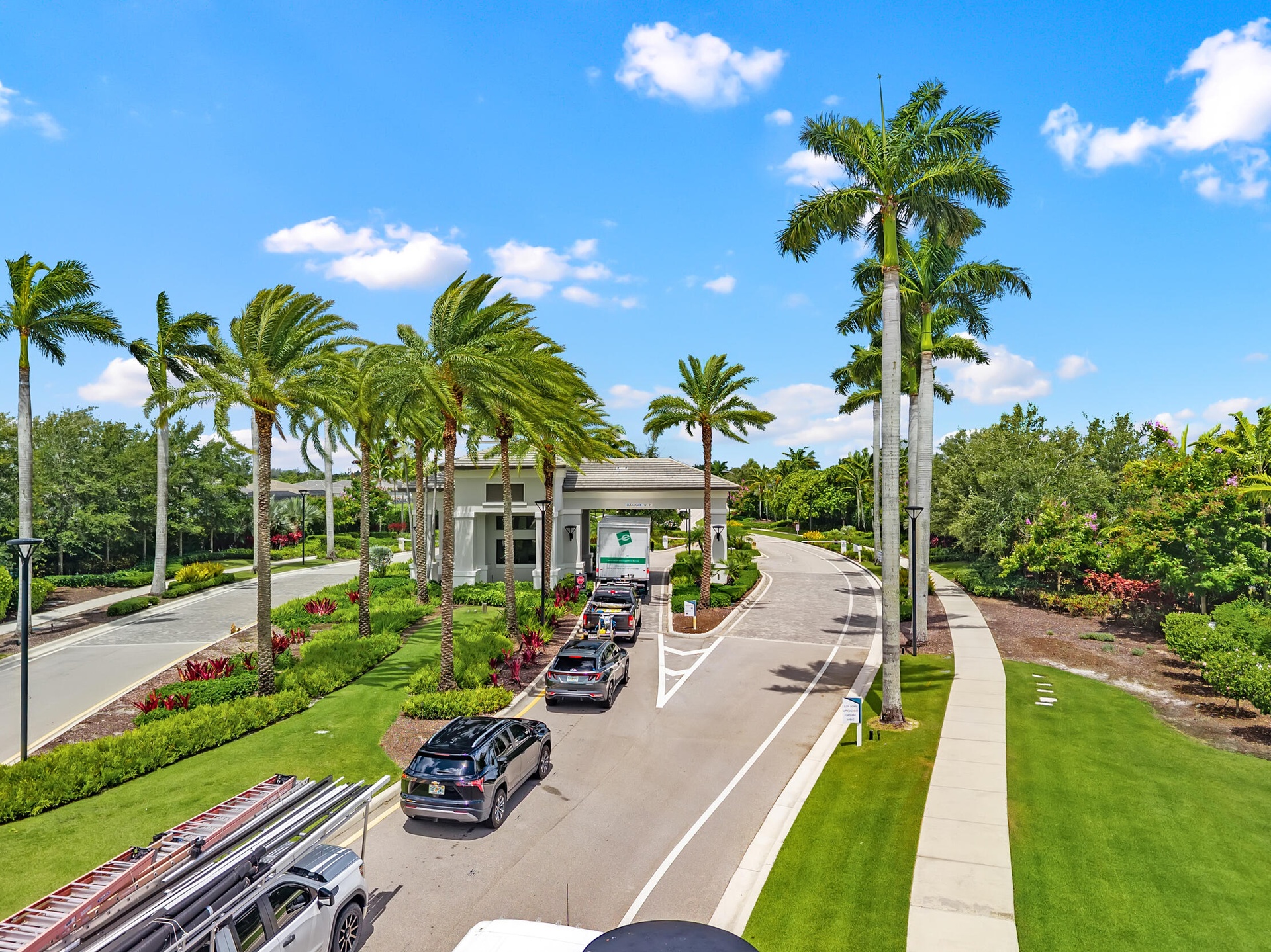 Grand gated entrance with 24-hour guard-gated security and lush tropical landscaping.