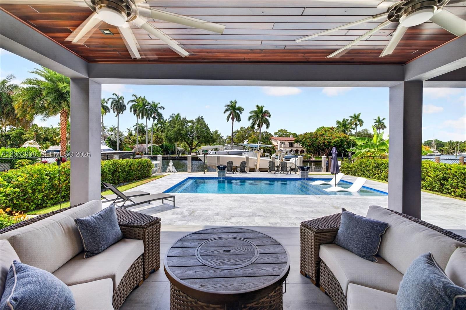 Covered patio w/ T&G ceilings, fans, fire pit seating and outdoor kitchen overlooks the gorgeous wide New River views and pool area