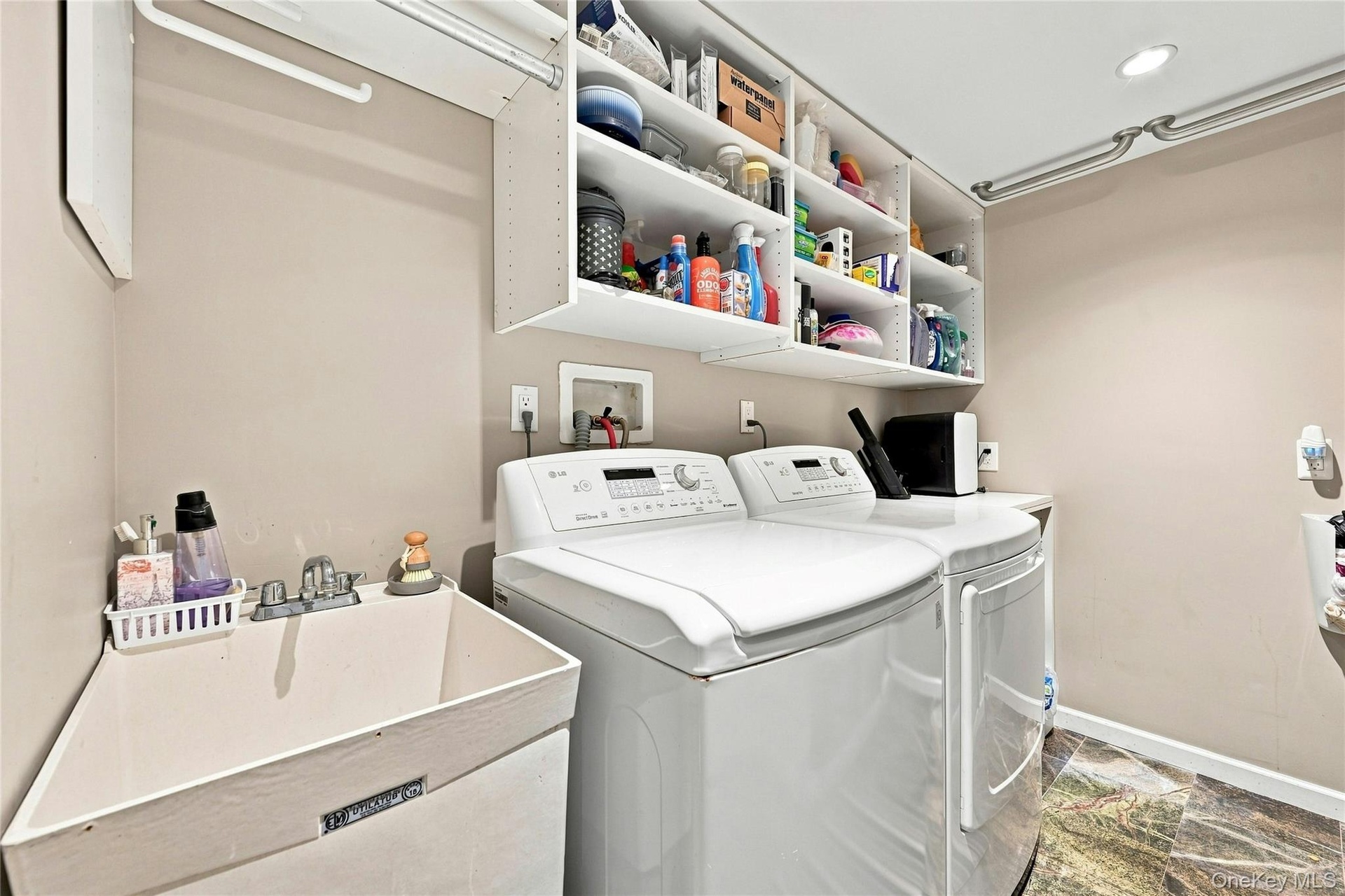 Main floor laundry room with storage and slop sink