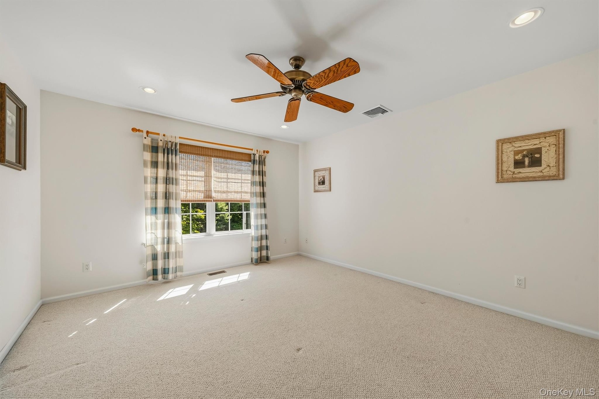 Carpeted room featuring a ceiling fan, recessed lighting, and ample natural light from a double window