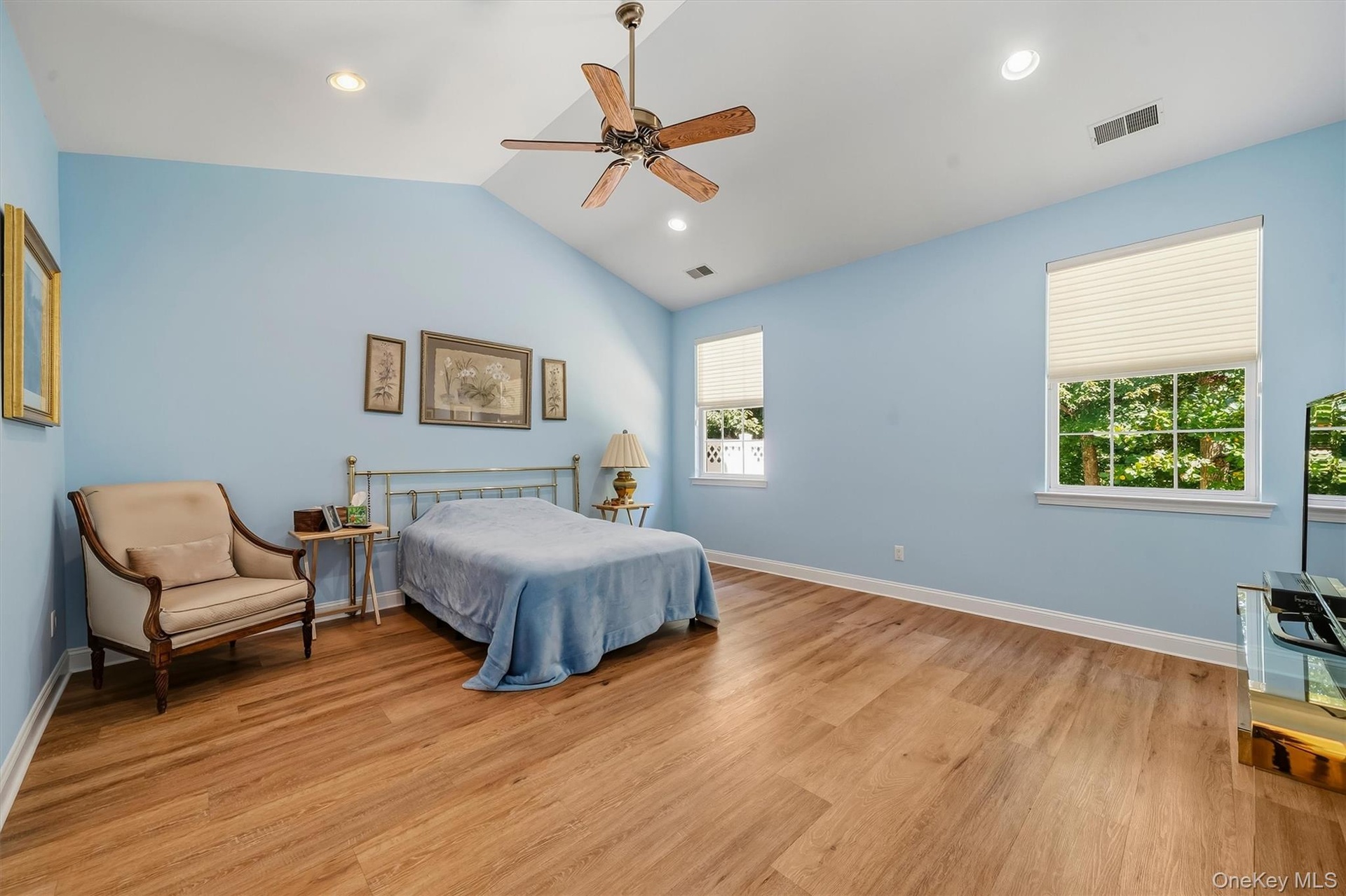 Vaulted ceiling with recessed lighting and a ceiling fan, wood-finish flooring, and multiple windows with privacy blinds