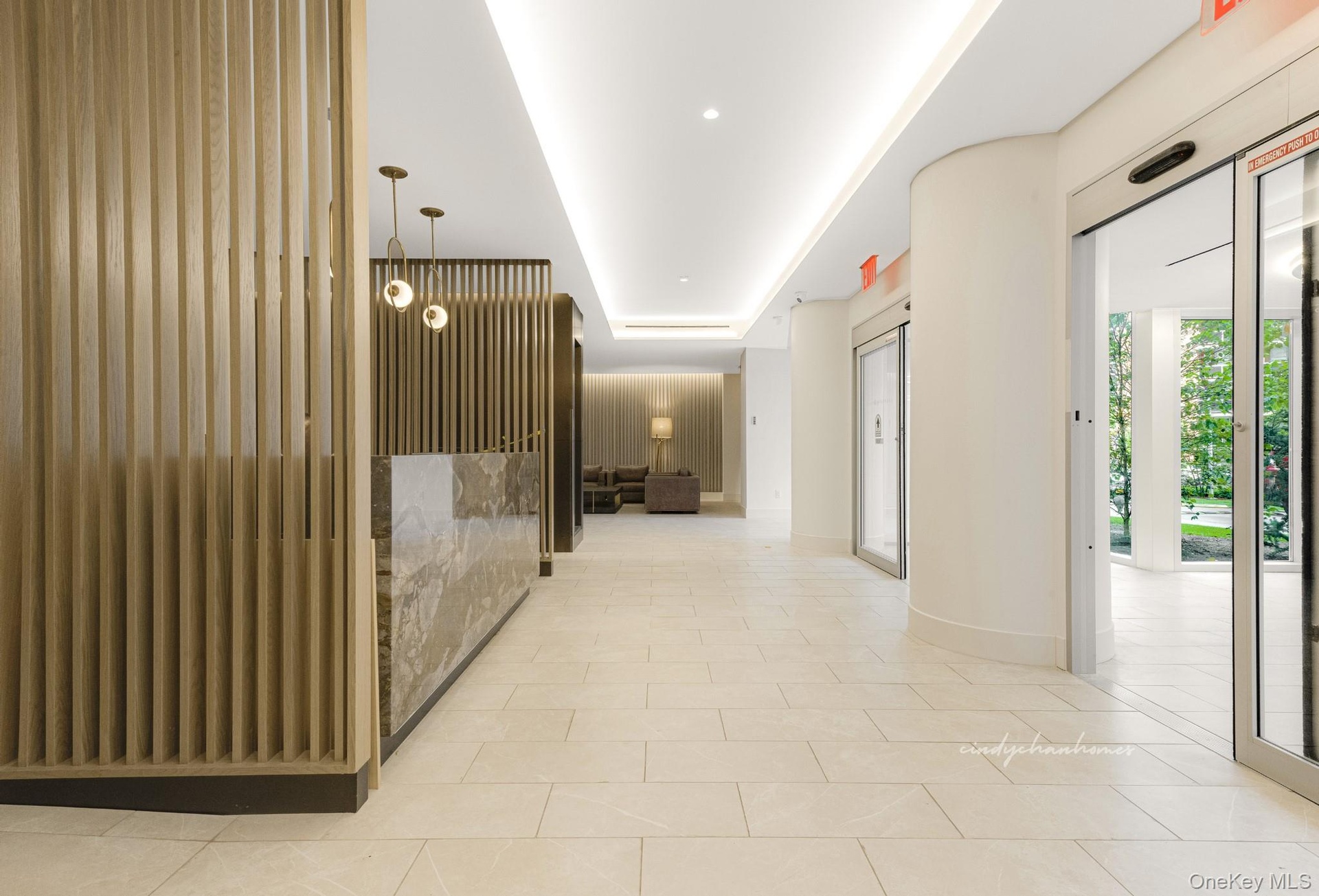 Hall featuring light tile patterned flooring and a raised ceiling