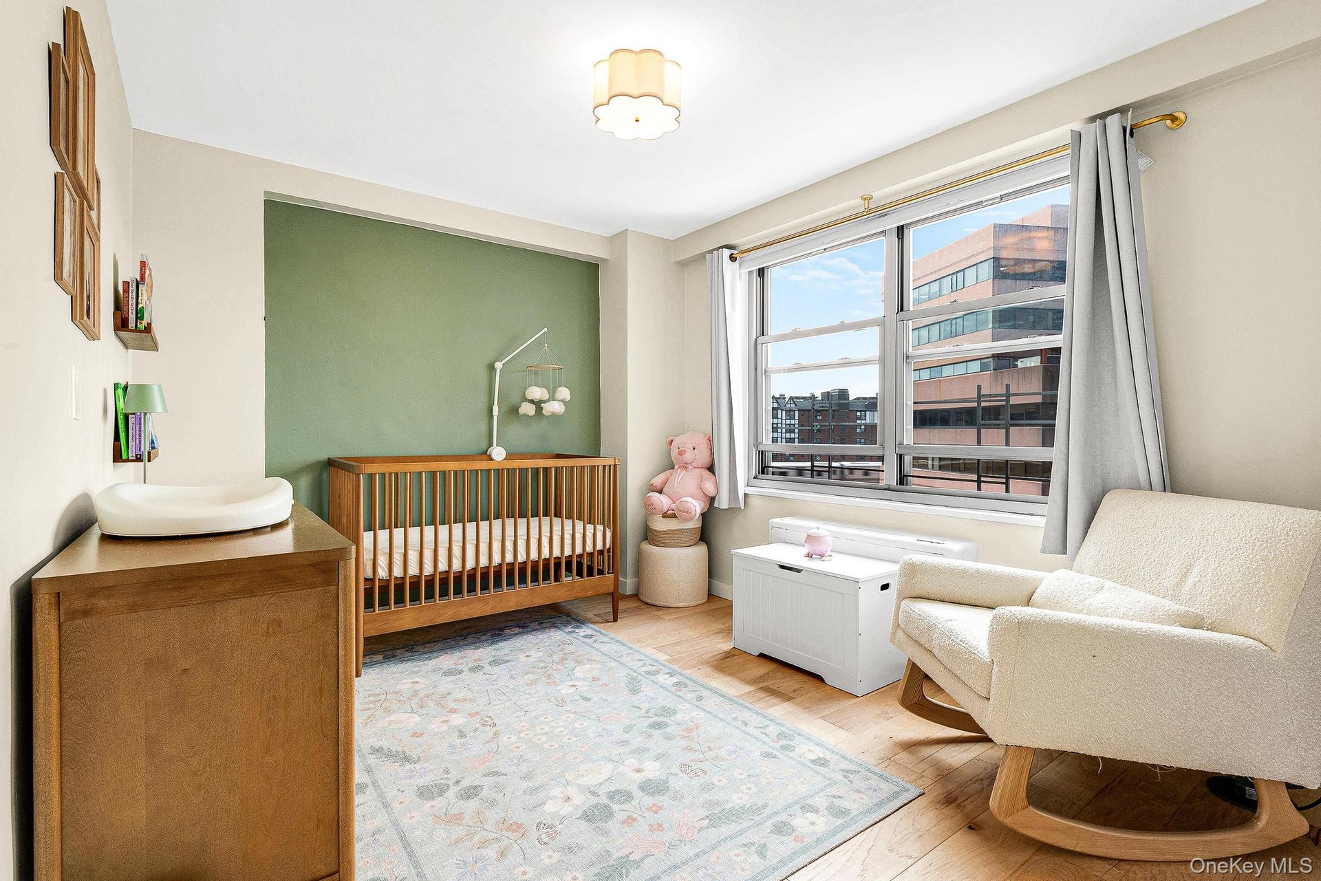 Bedroom featuring a nursery area and wood finished floors