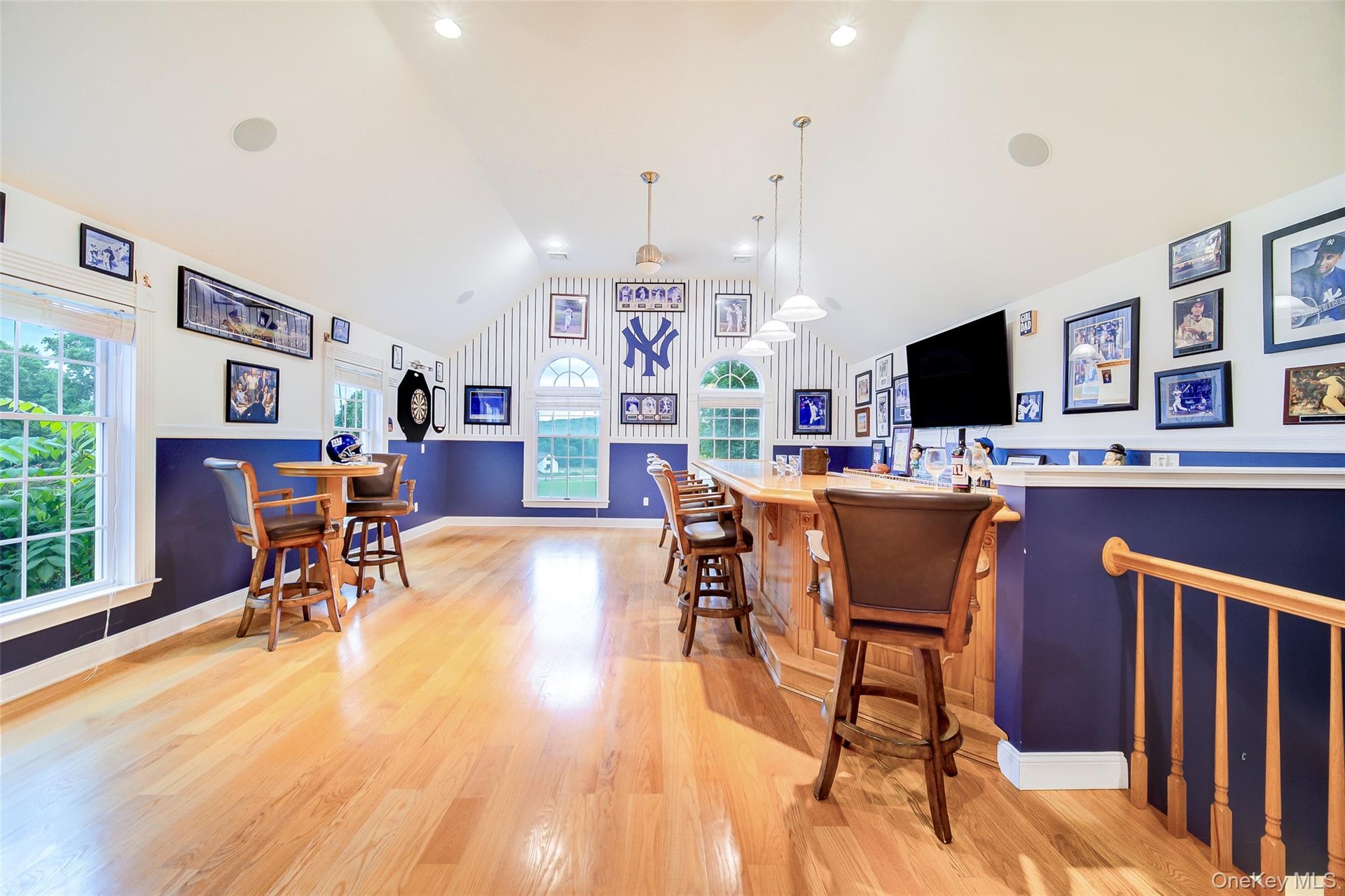 Bonus room has recessed lighting, hardwood floors, multiple windows, a door to the side yard and a full bath in the space