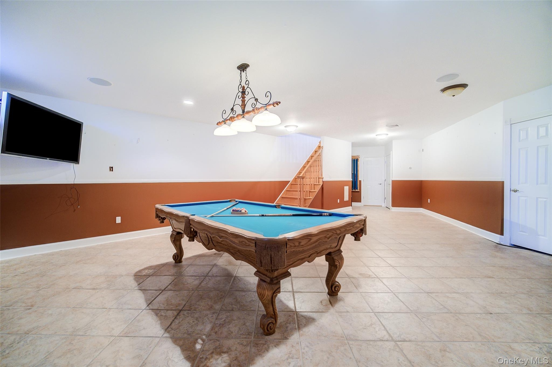 Spacious recreation area featuring tile flooring, recessed lighting, and a built-in sound system