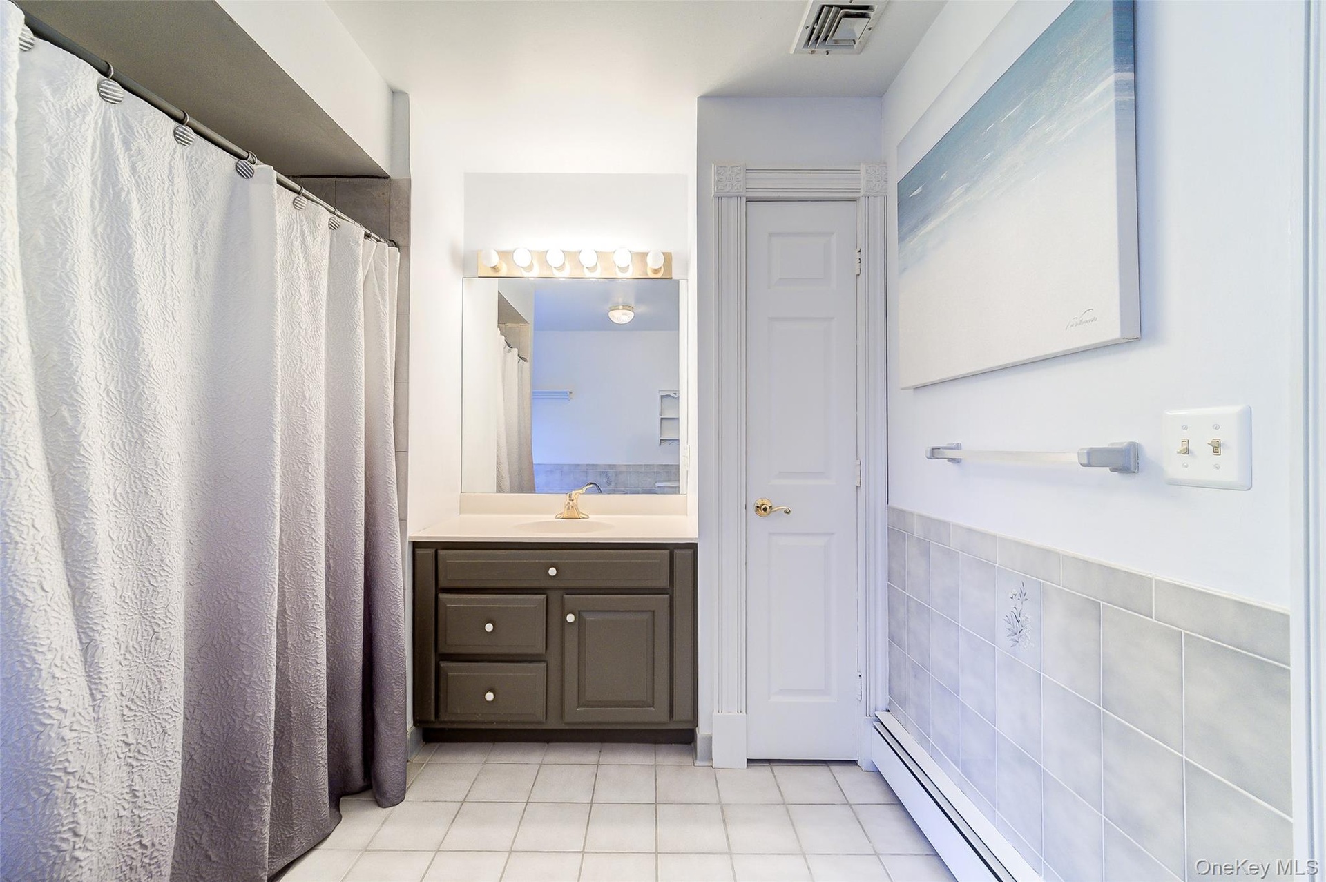 White tile flooring and a shower can be found in en-suite