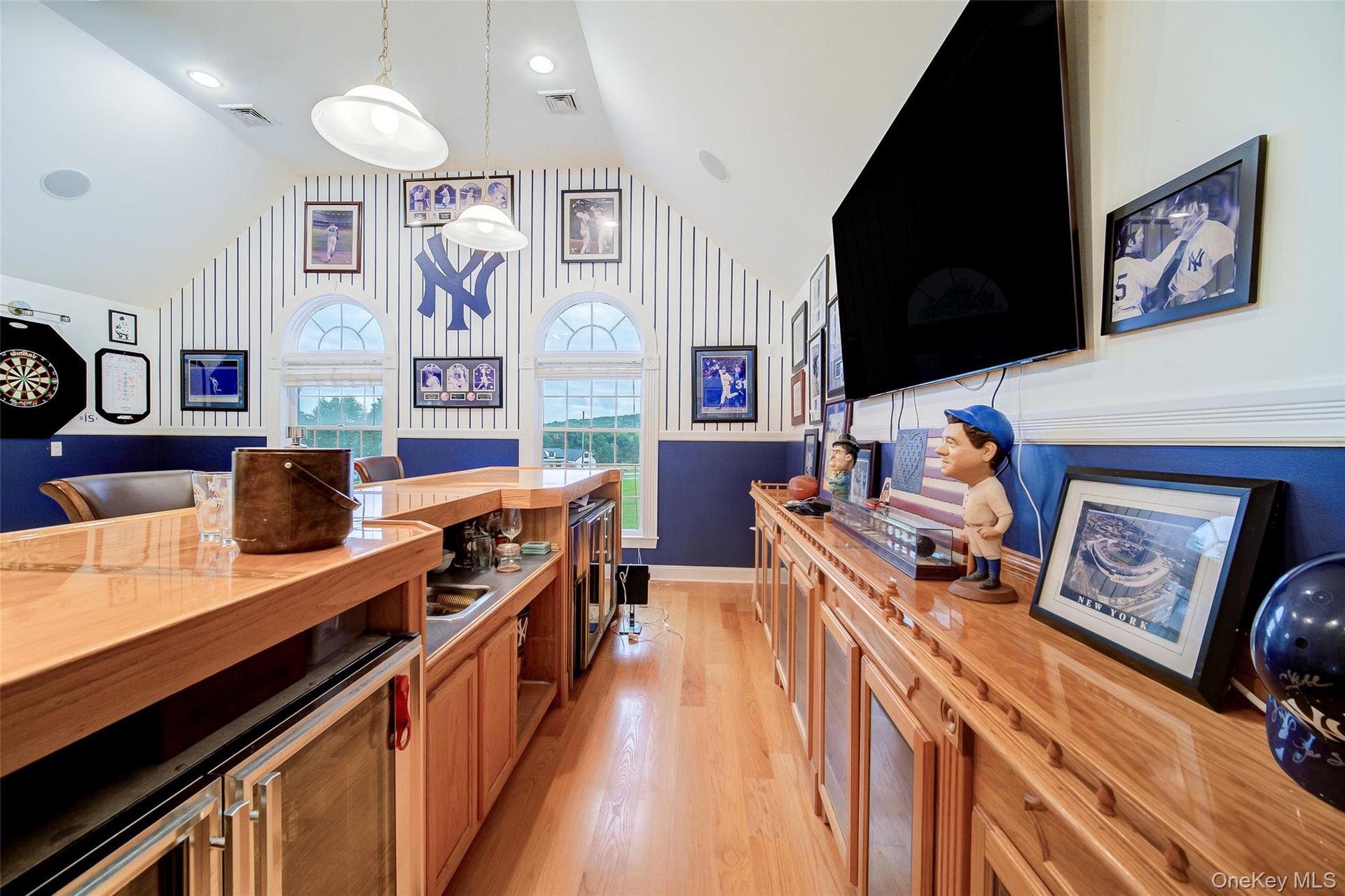 Built-in wet bar with integrated appliances, including refrigeration, a sink and a built-in media console.