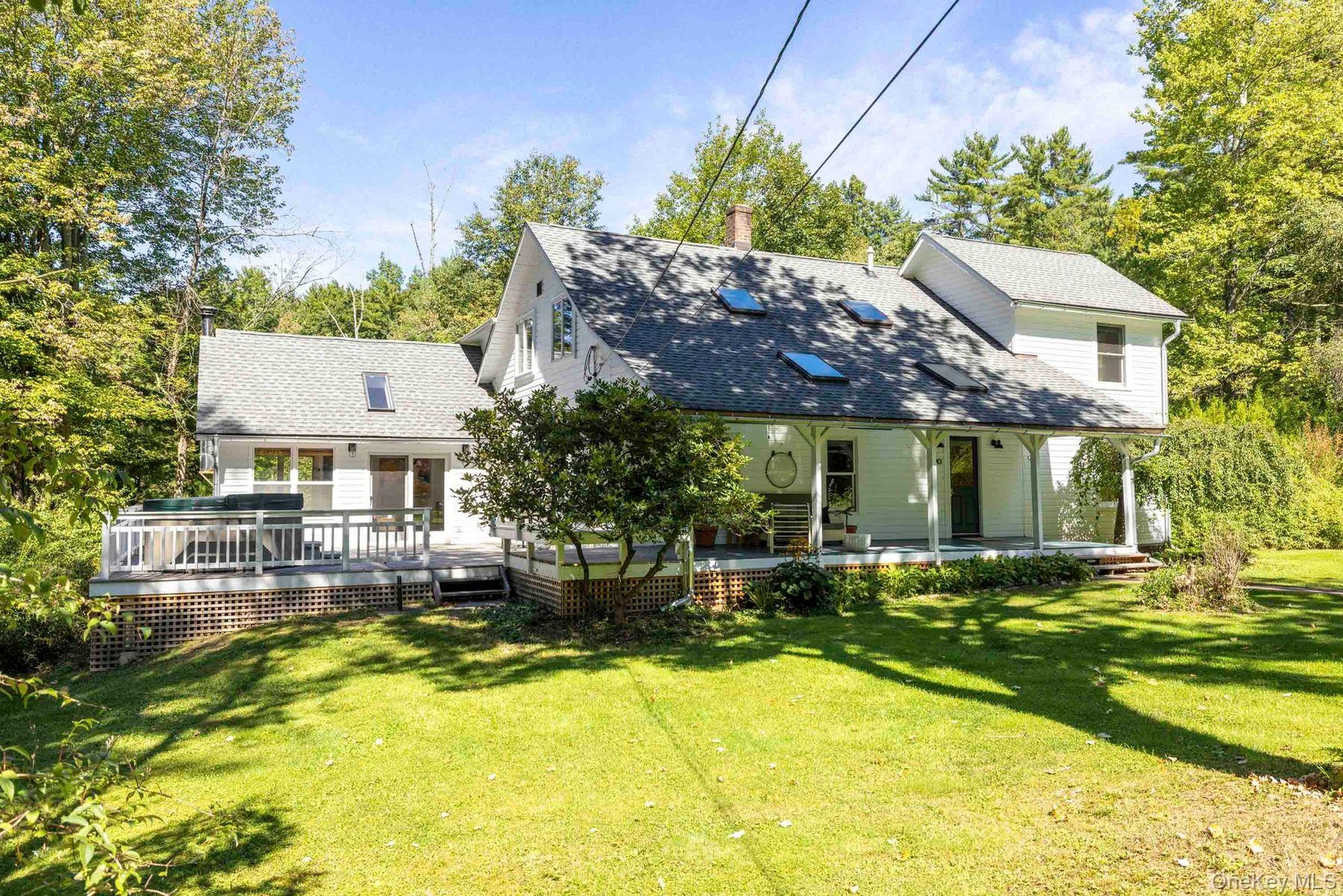 Exterior siding, covered front porch, skylights, pitched roof, and outdoor deck