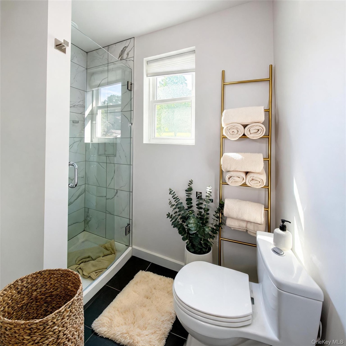 Virtually staged. Bathroom with glass walk-in shower and natural light from the window.