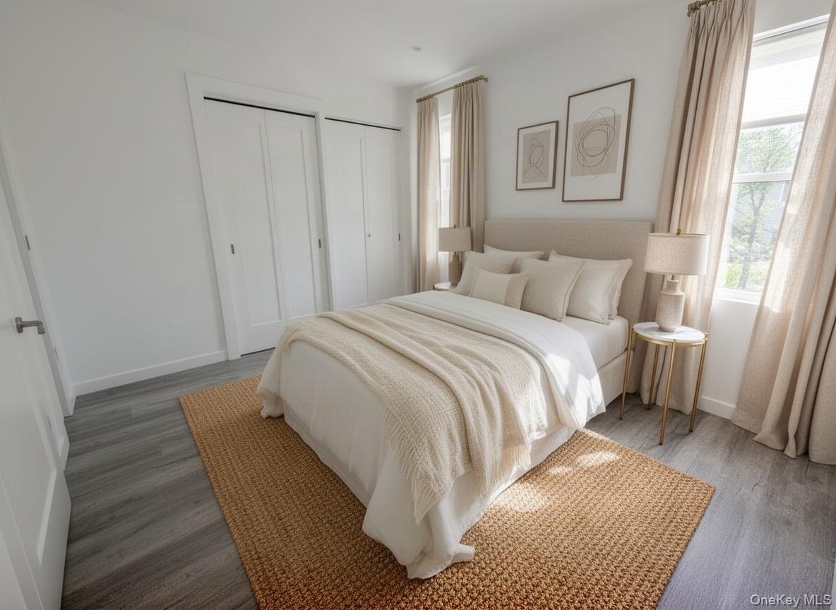 Virtually staged. Primary bedroom with double closets, window and wood-look flooring.