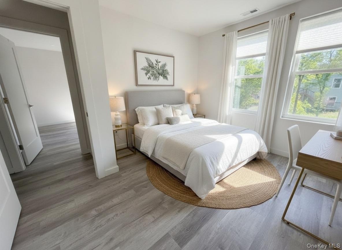 Virtually staged. Bedroom with closet and window, shown with a bed and desk area.
