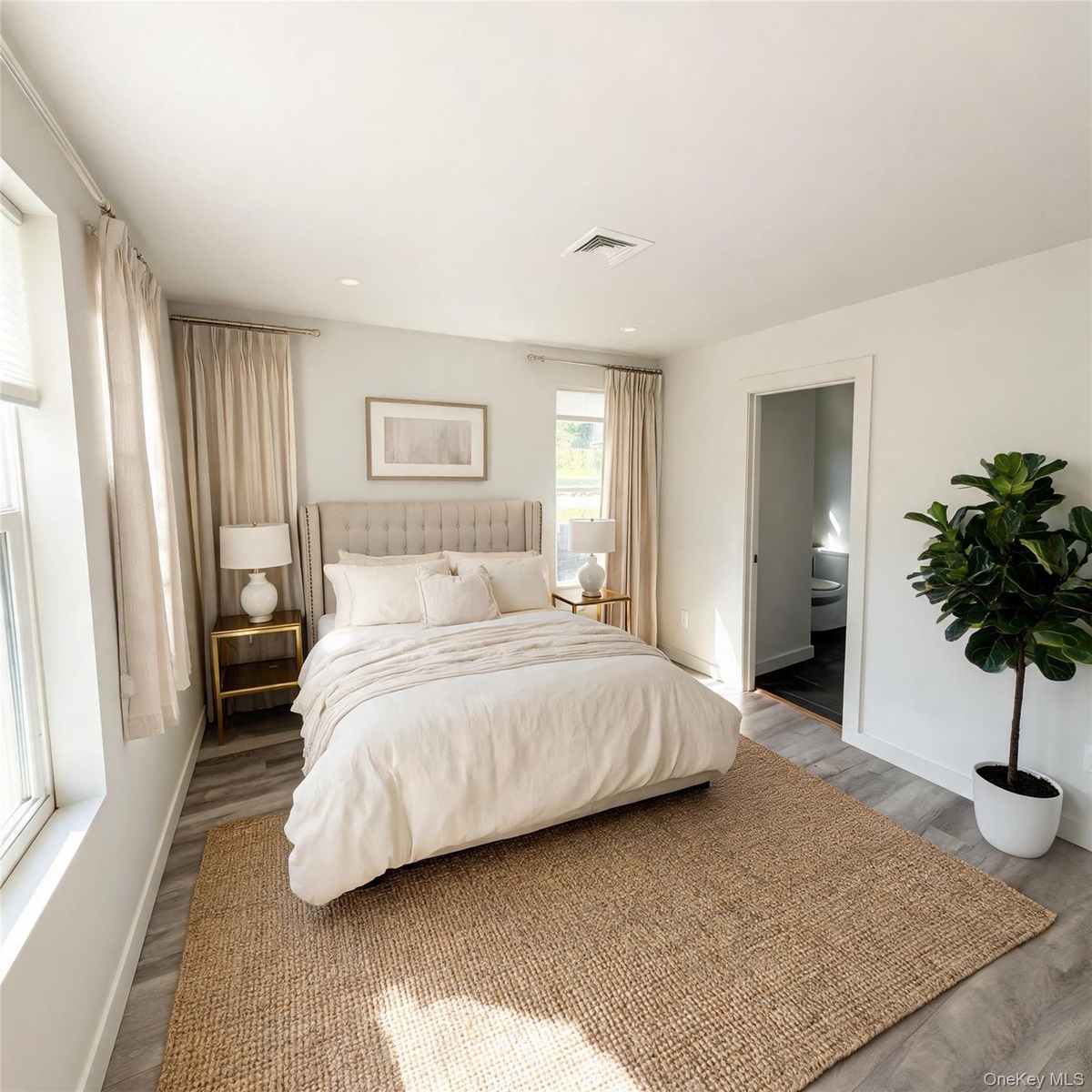 Virtually staged. Bedroom with window, doorway to the hall and wood-look flooring.
