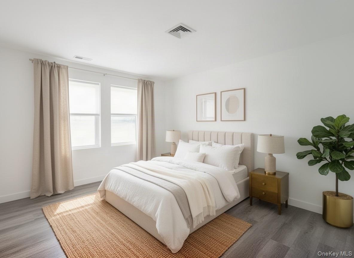 Virtually staged. Bedroom with two windows, recessed lighting and wood-look flooring.