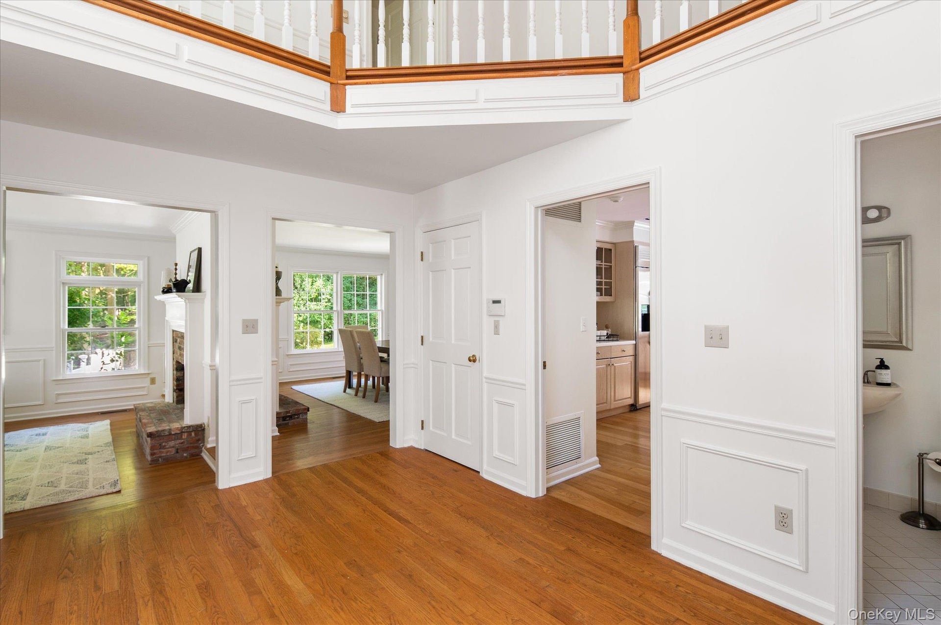 Shows living room, dining room, guest closet, door to kitchen, half bathroom and partial view of balcony