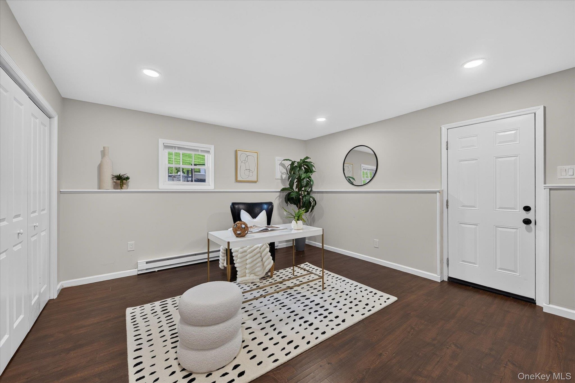 Huge office in lower level--Dark wood-finish flooring, recessed lighting, double bi-fold closet doors, white paneled door, and a single-pane window