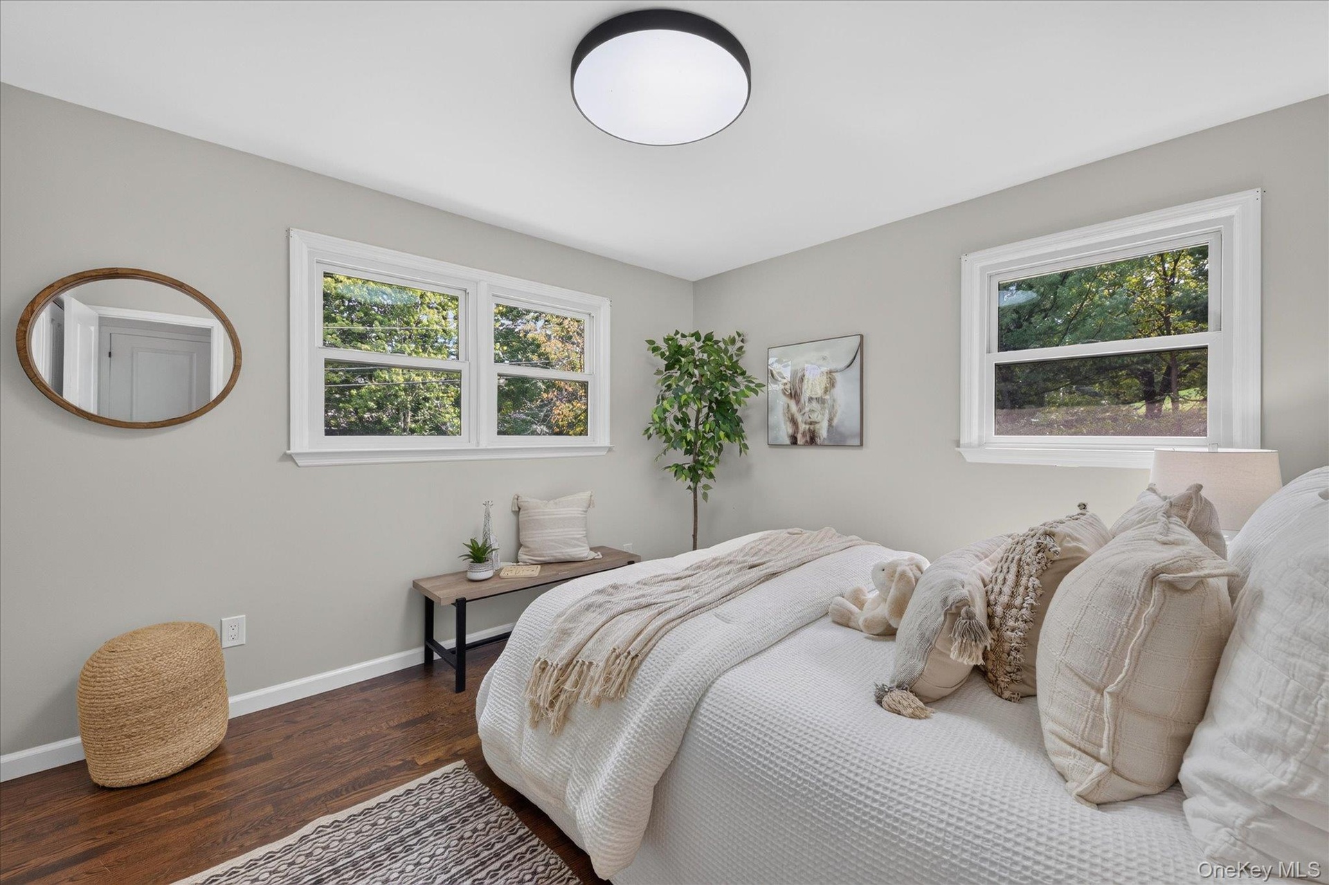 Hardwood-style flooring, light gray walls, white trim, recessed lighting fixture, and multiple windows