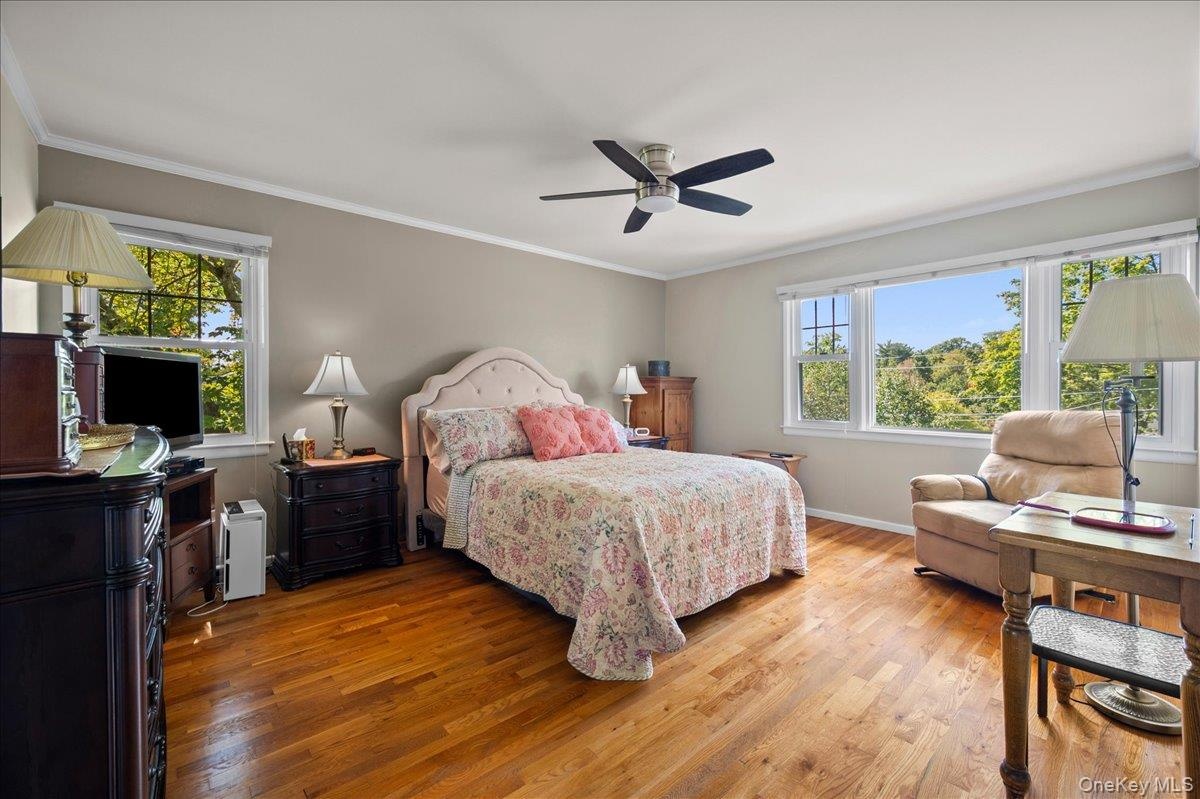Primary bedroom with oak floors and wall of windows