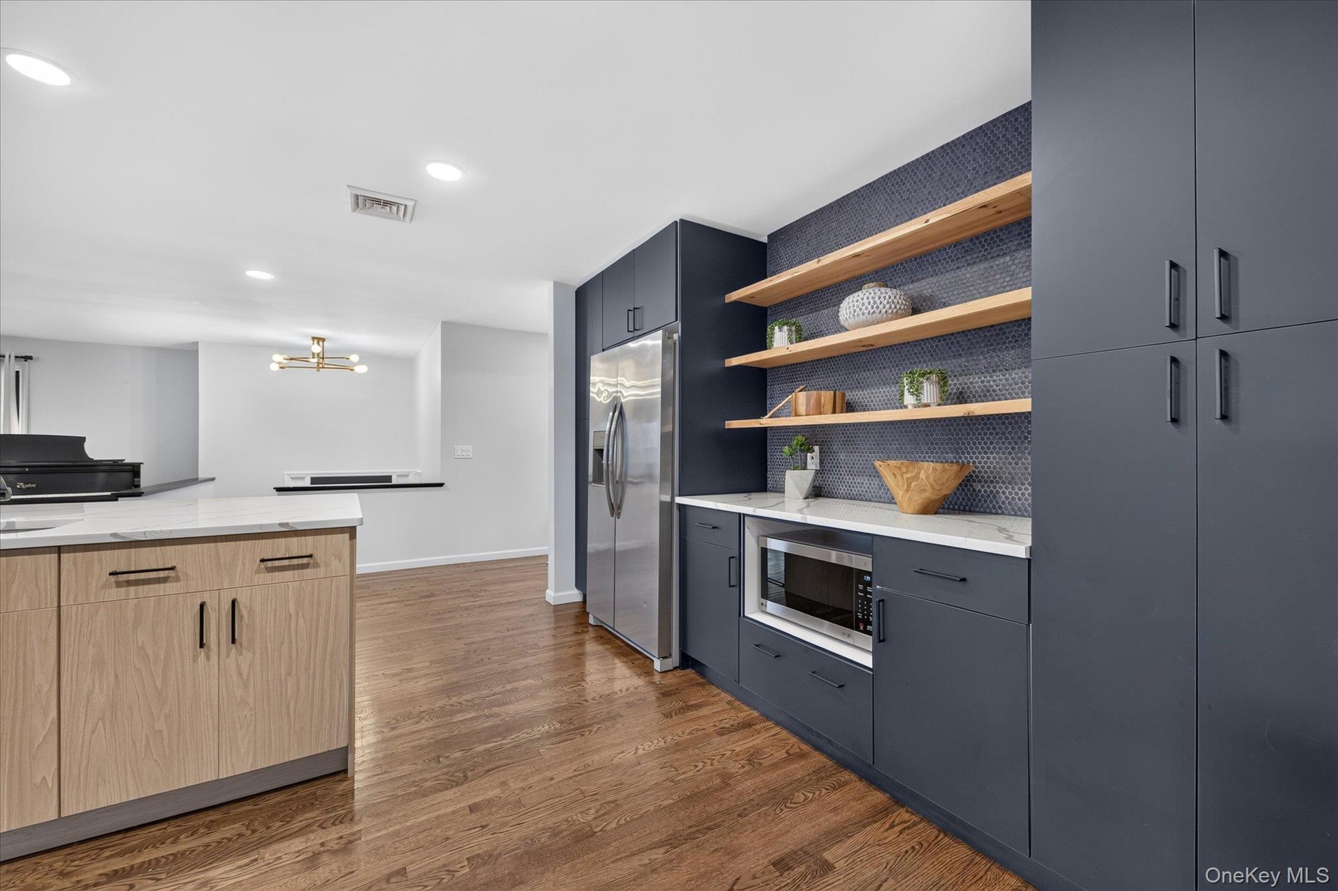 Custom kitchen island with light wood-finish cabinetry and a white countertop