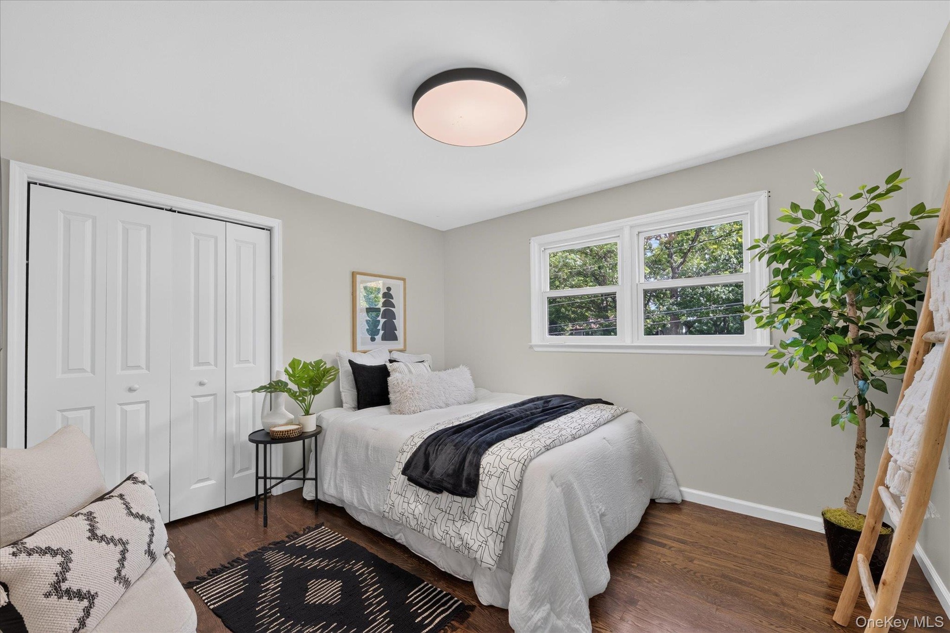 Hardwood flooring, light gray wall paint, white trim, recessed lighting, and white bi-fold closet doors