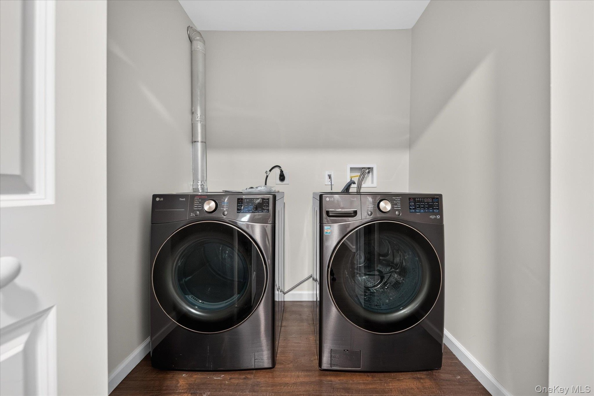 State of the art washer and dryer. Dedicated laundry area with a dark wood-finish floor