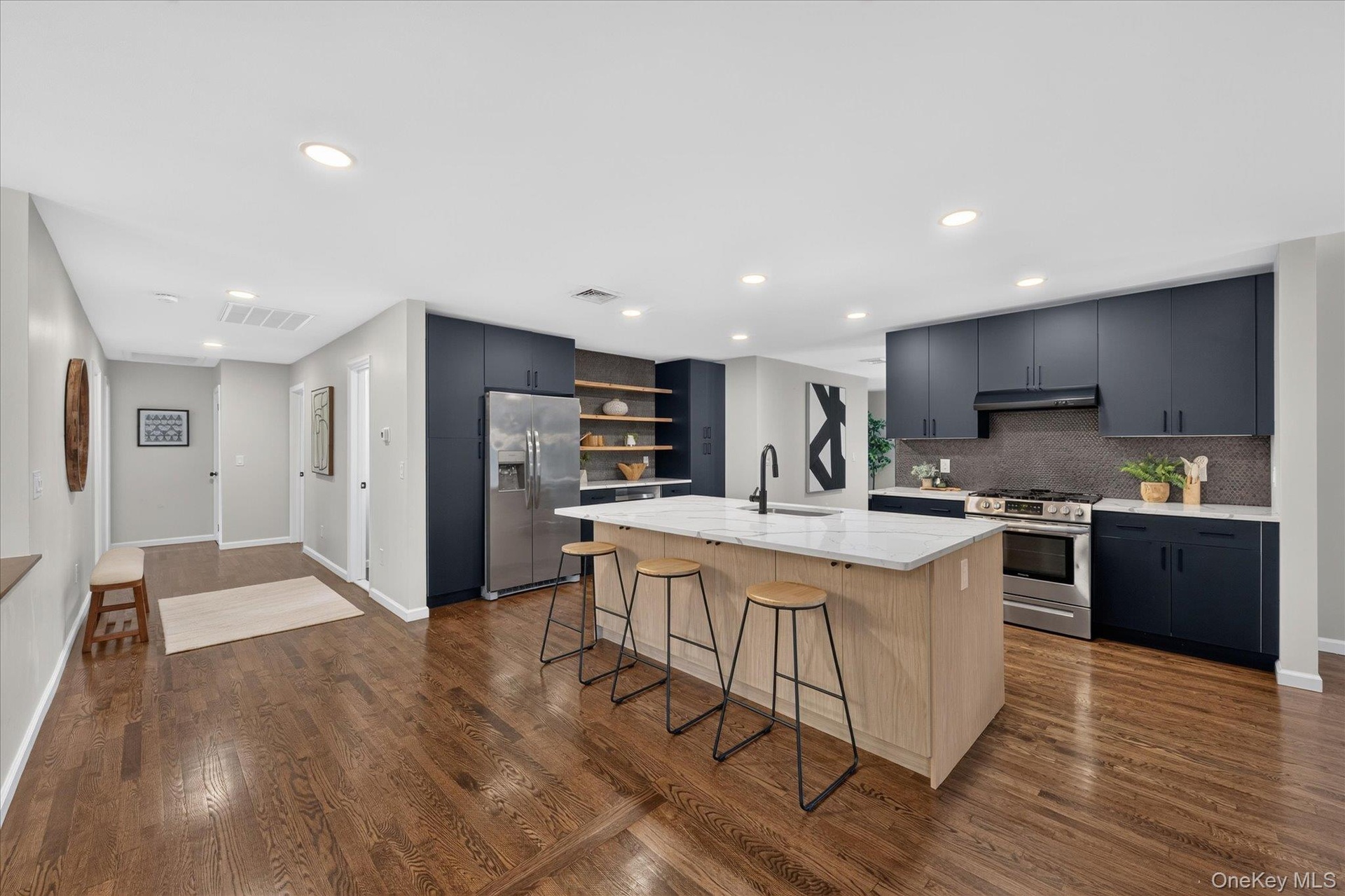 Kitchen featuring a center island with countertop seating, dark blue cabinetry, wood-finish flooring, recessed lighting, and stainless steel appliance