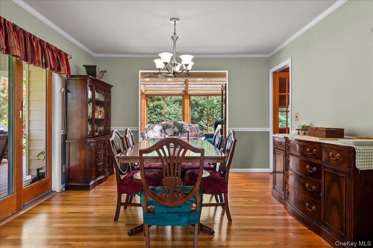 Dining room with oak floors and view into four seasons room