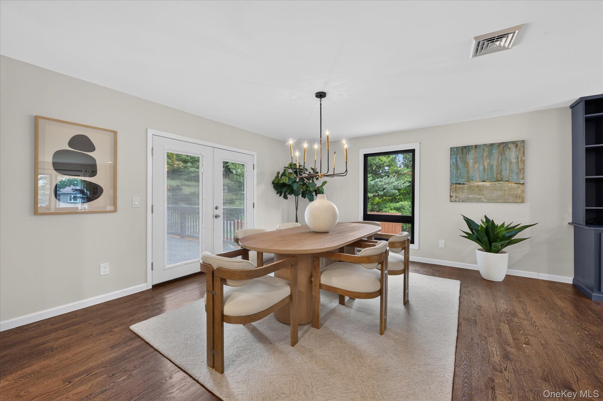 Hardwood flooring, French doors with exterior access, integrated shelving unit, and a black-framed window