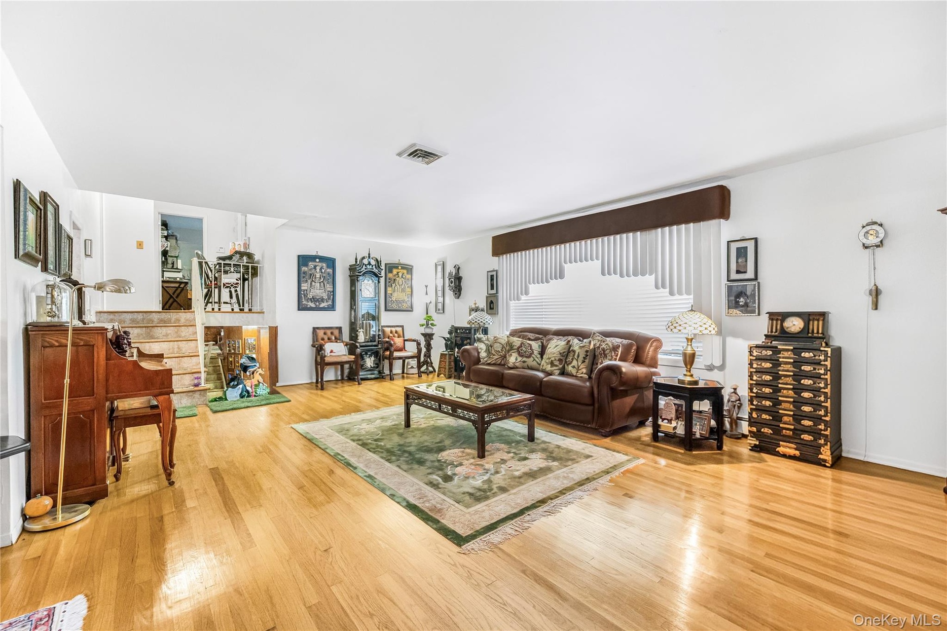 Light wood-finish flooring, white walls, and a multi-level floor plan with visible stairs