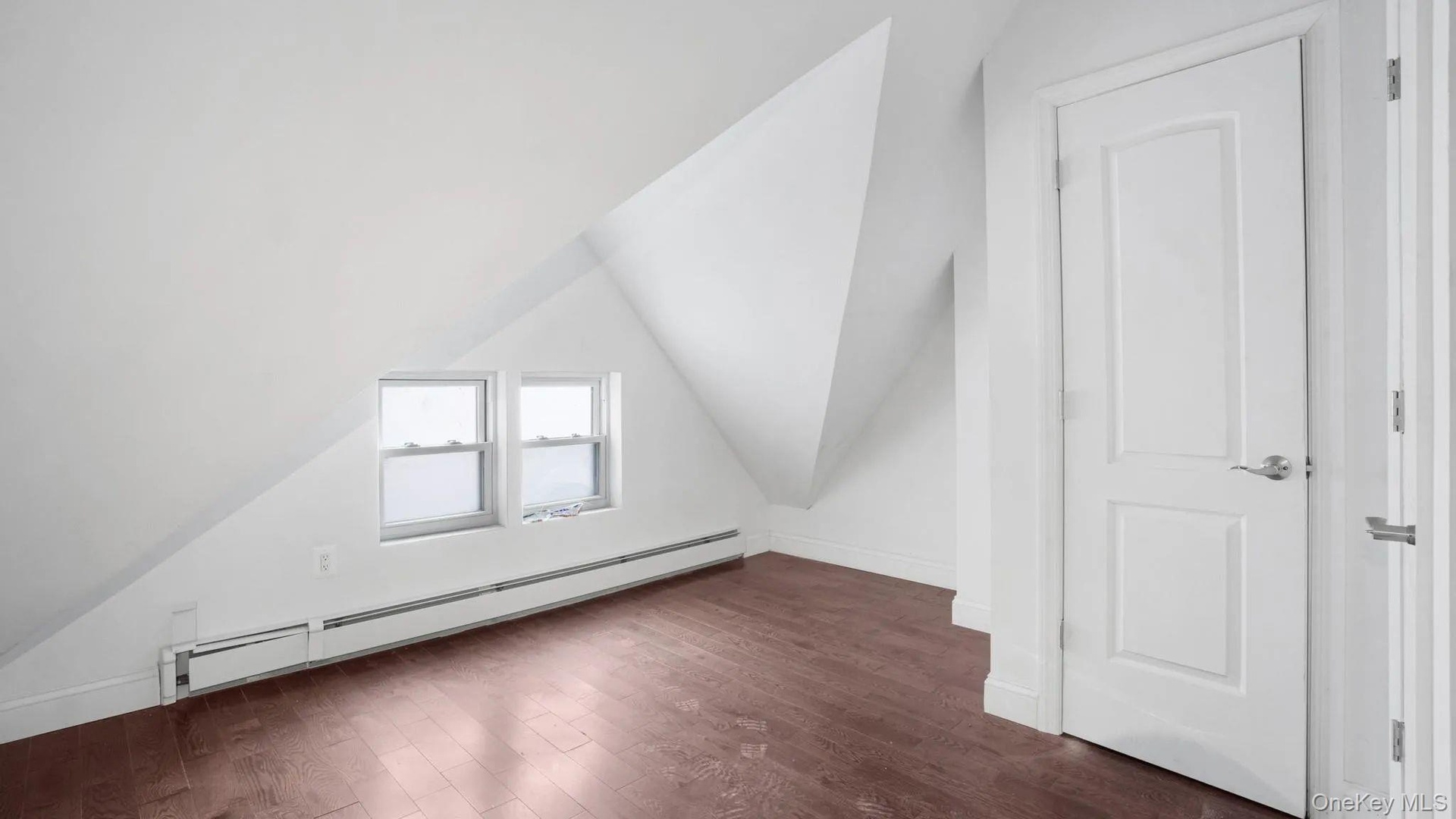 Bonus room with dark hardwood / wood-style flooring, a baseboard radiator, and lofted ceiling